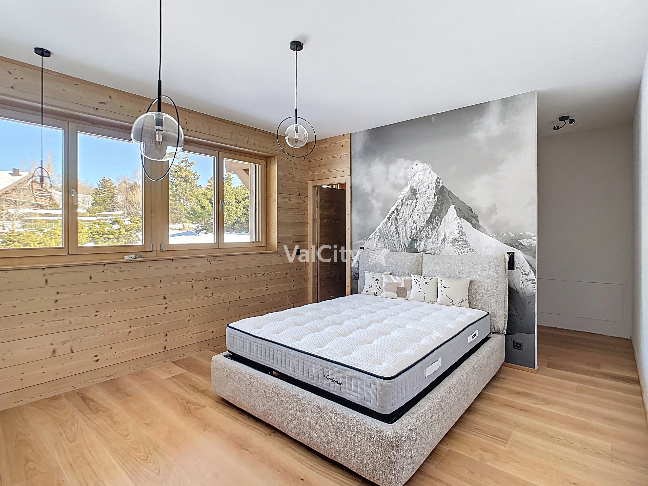 Helles Schlafzimmer mit Holzverkleidung und Bergmotiv