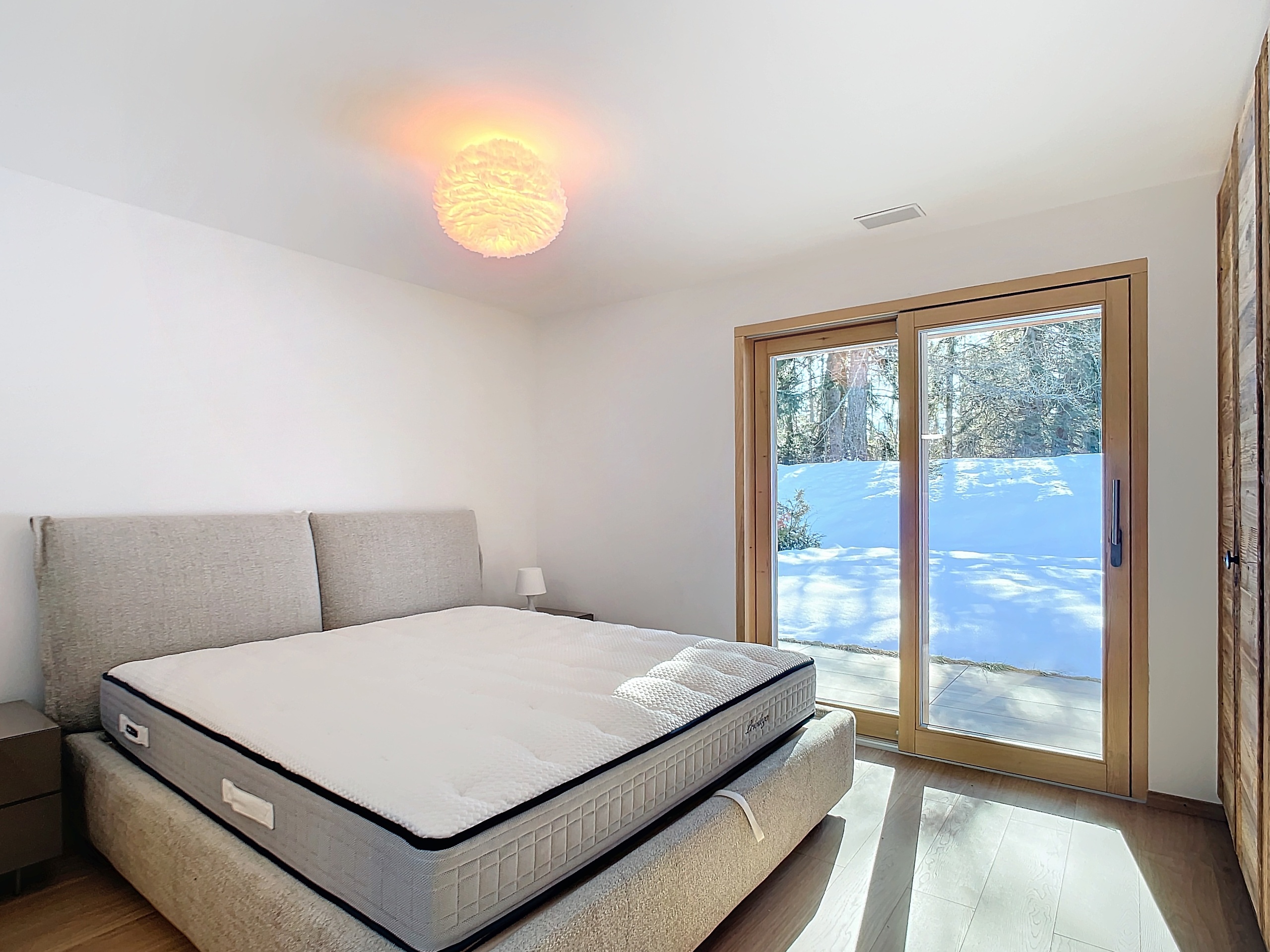 Helles Schlafzimmer mit Blick ins verschneite Freie