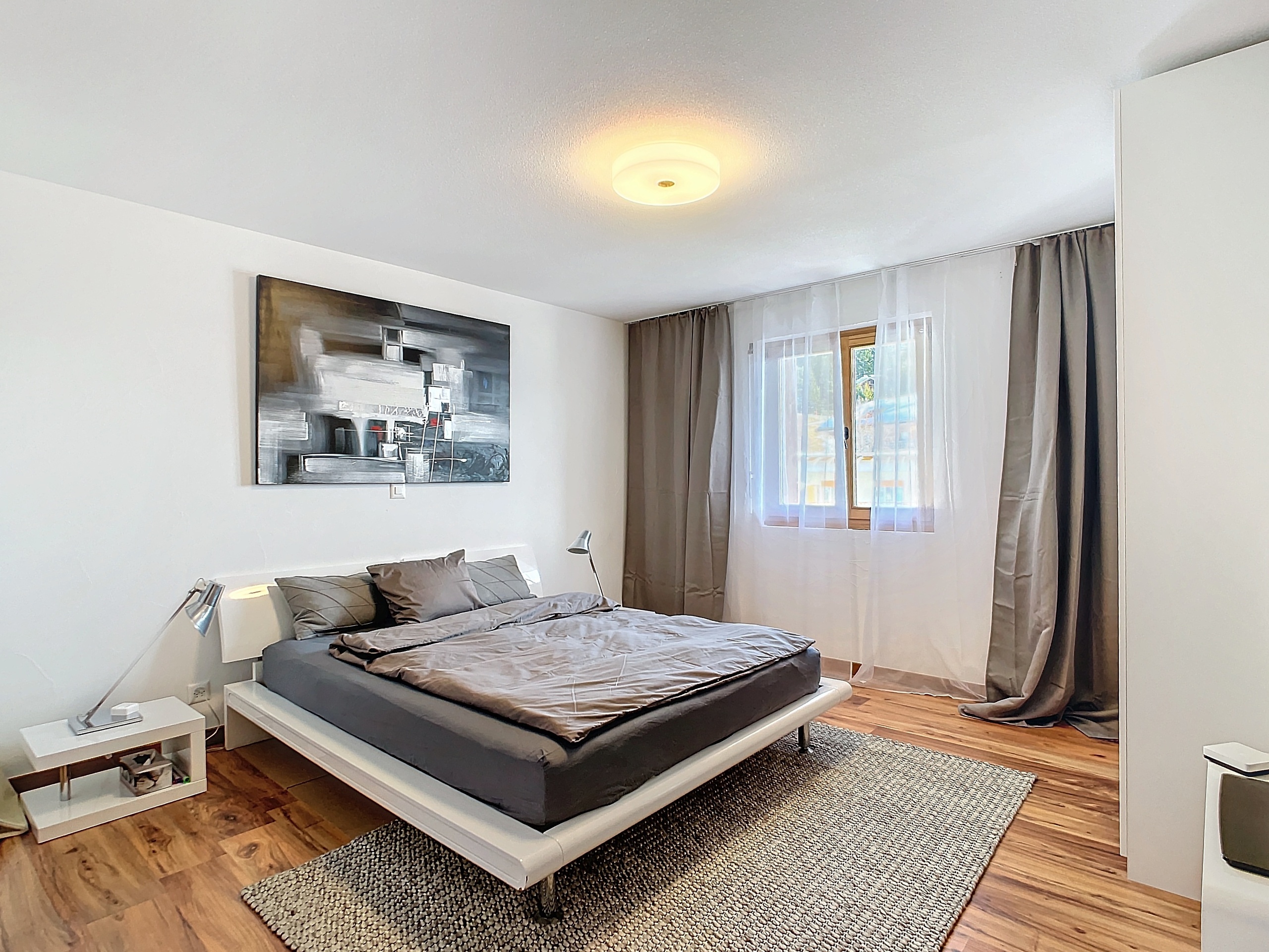 Modernes Schlafzimmer mit großem Bett und Tageslichtfenster