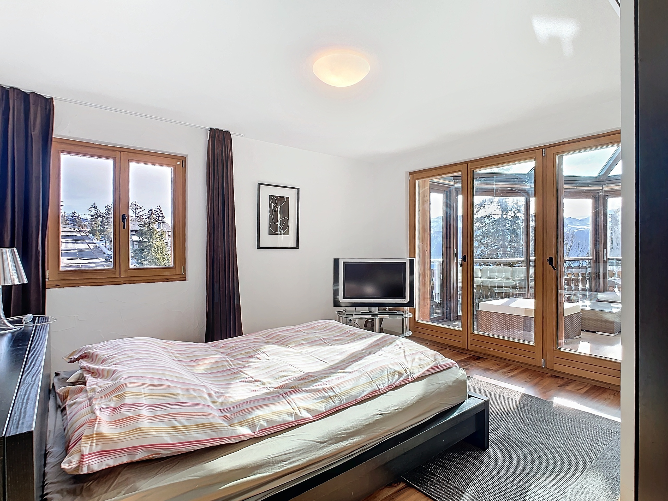 Helles Schlafzimmer mit großer Verglasung und Bergblick
