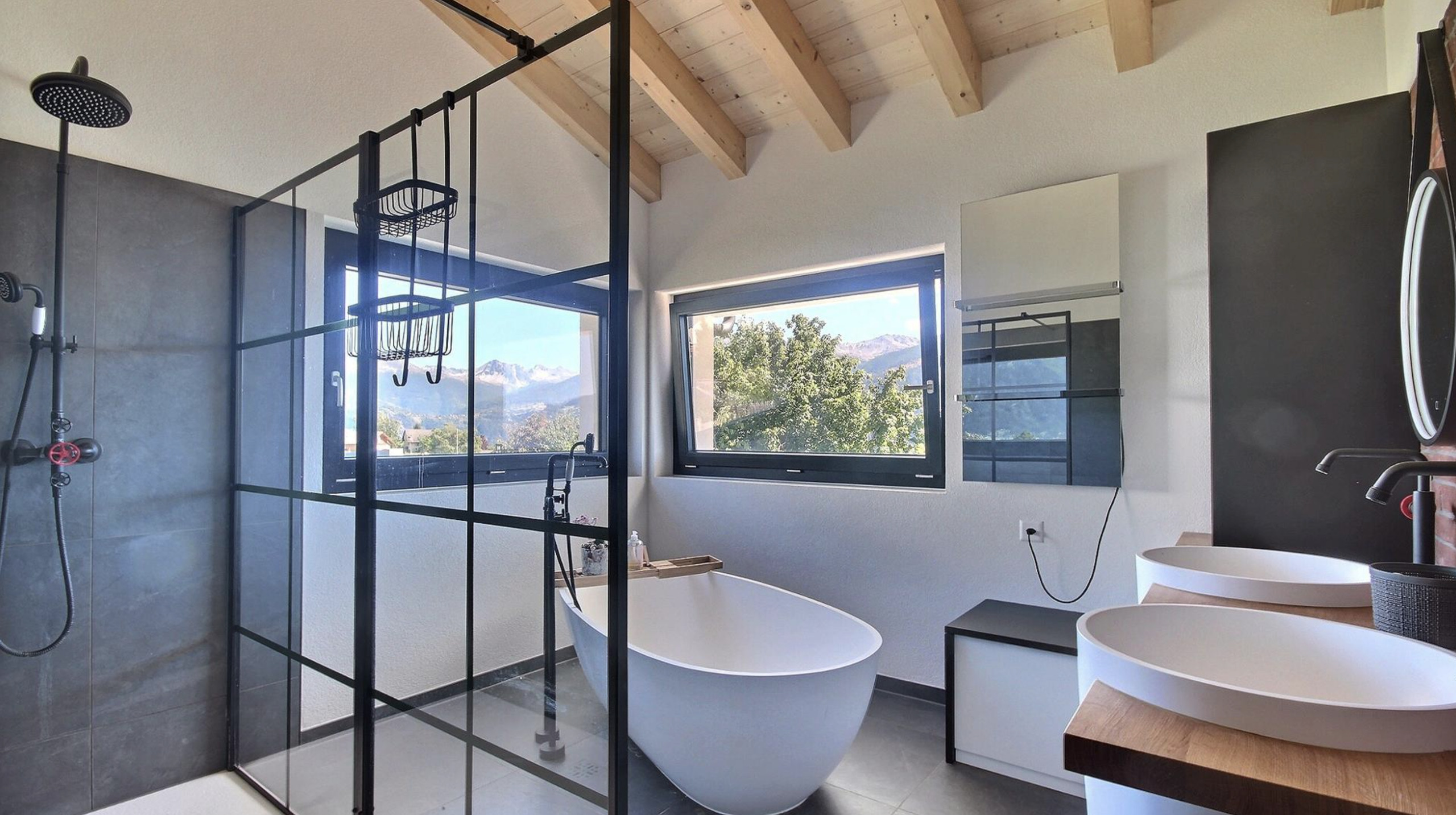 Modernes Badezimmer mit freistehender Wanne und Bergblick