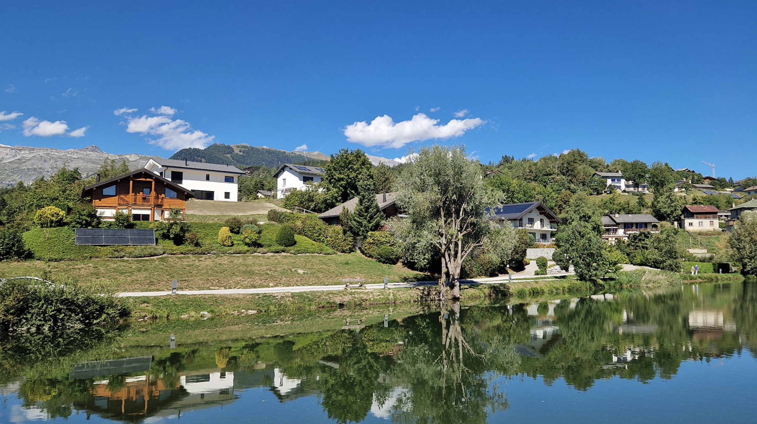 Alpensee mit Wohnhäusern