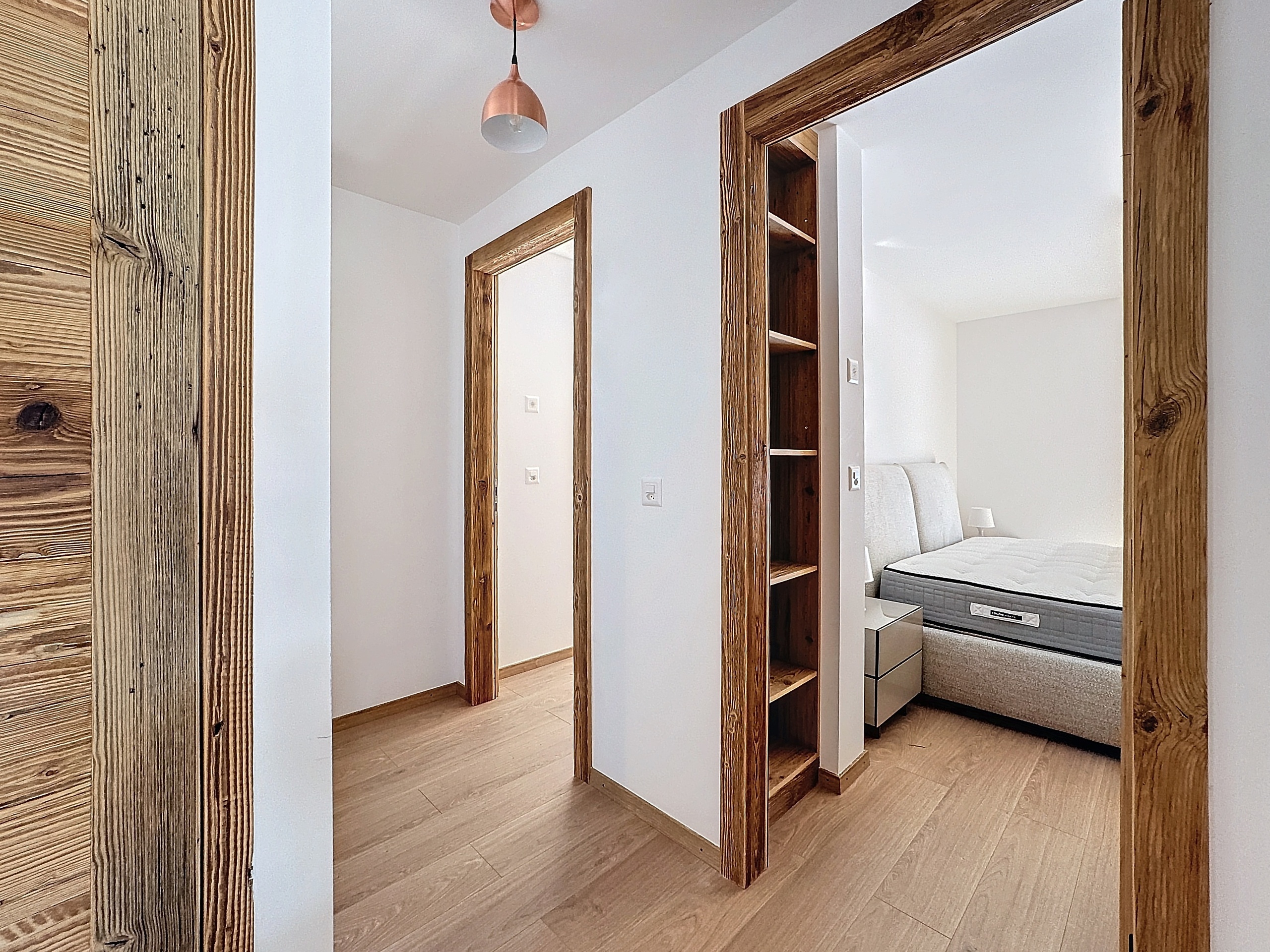 Heller Schlafbereich mit Flur und Holztüren