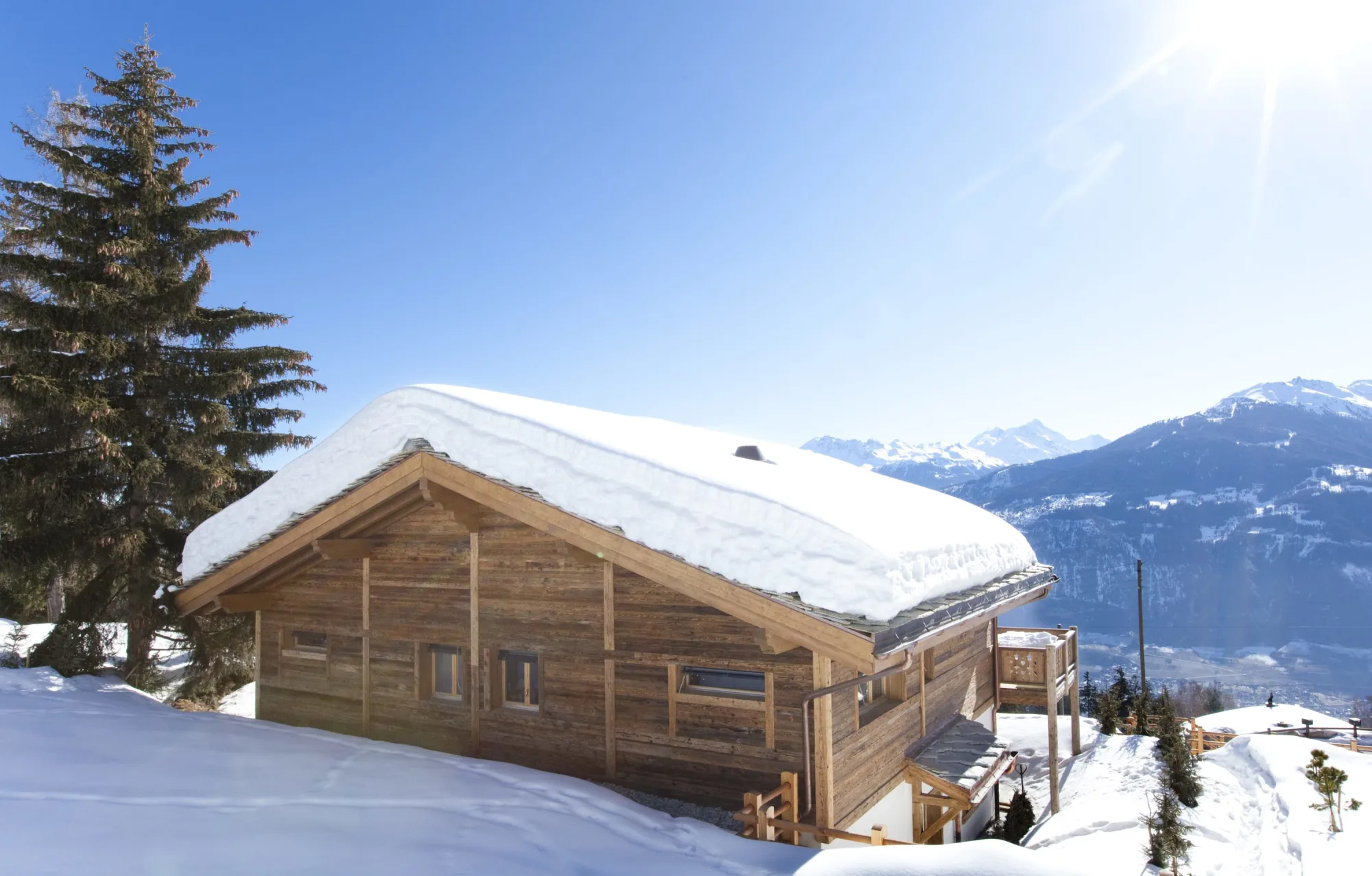 Schneebedecktes Holzchalet mit Bergblick