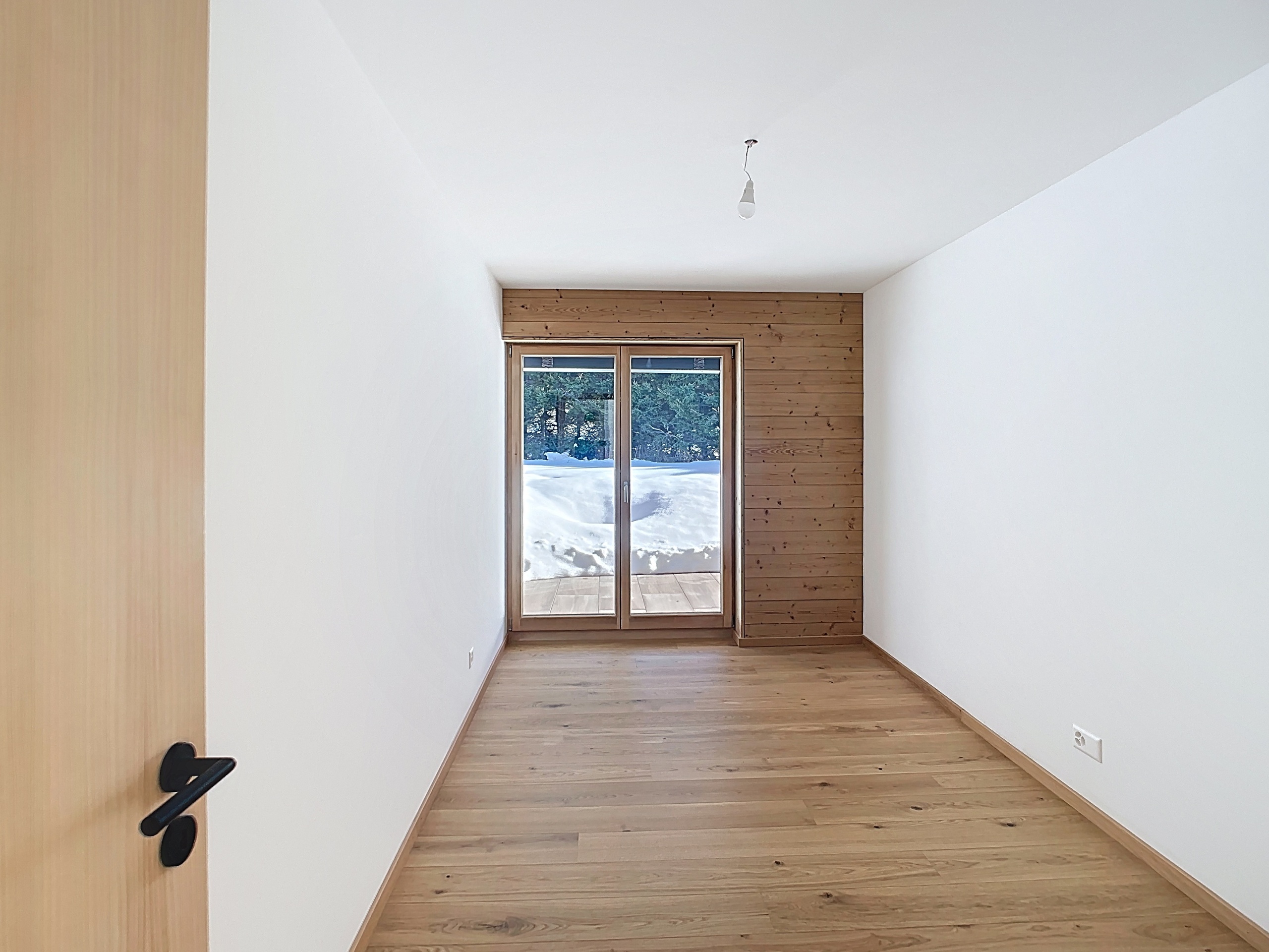 Heller leerer Raum mit Holzakzenten und Blick ins Freie
