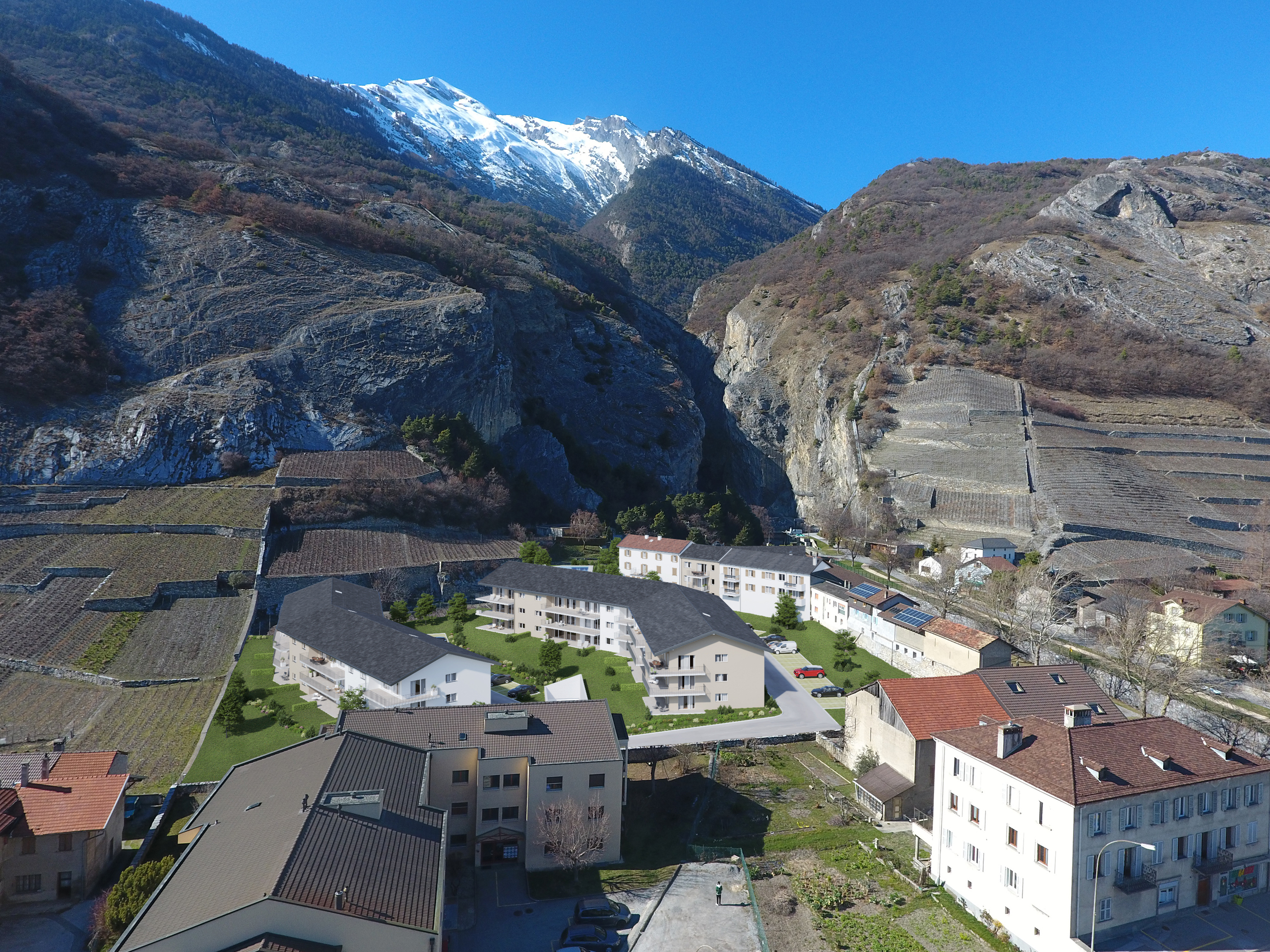 Luftaufnahme eines alpinen Wohngebiets mit Bergkulisse