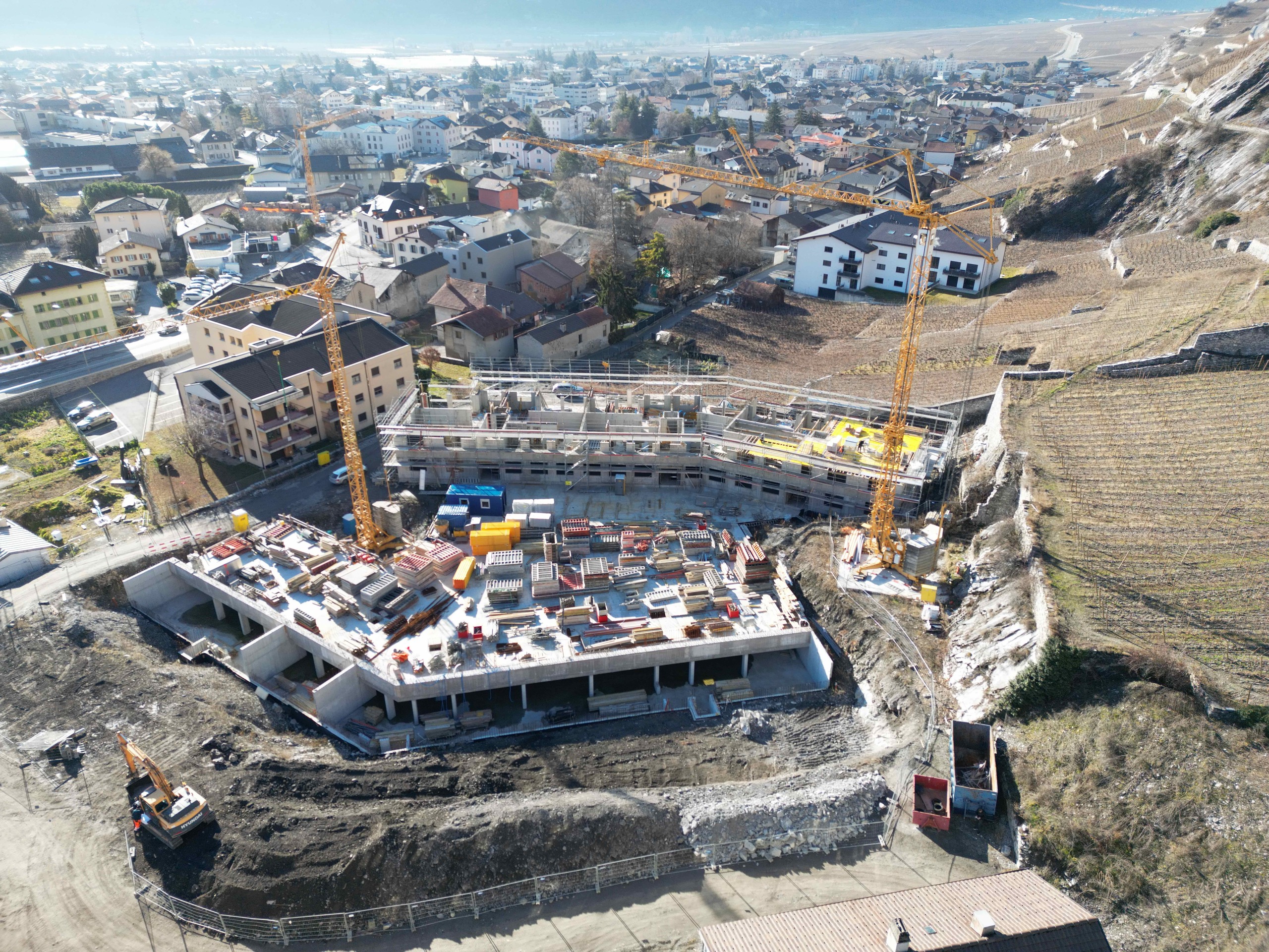 Große Baustelle mit Wohnanlagen im Hang