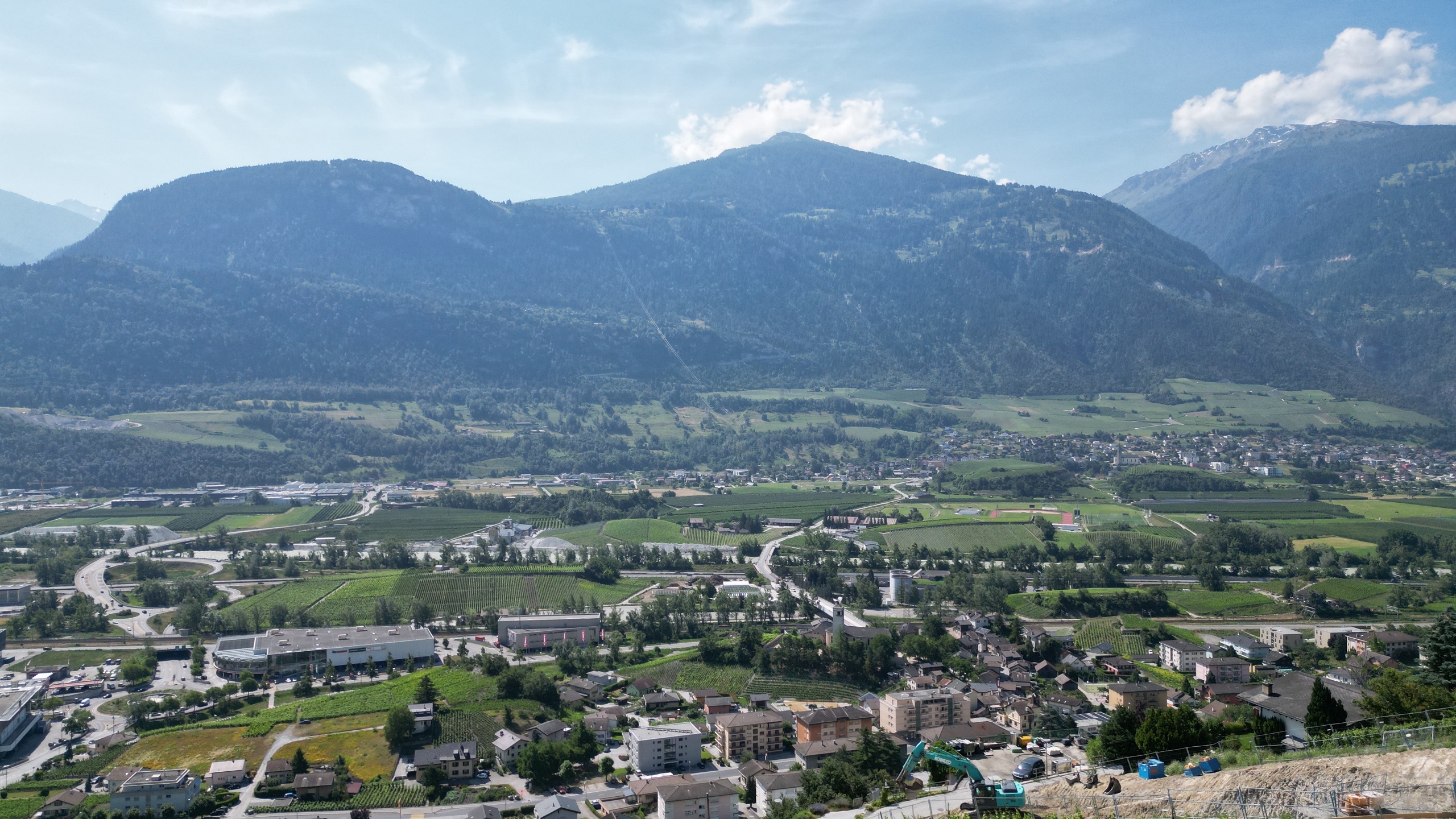 Bergpanorama über ein Tal mit Siedlungen und Feldern