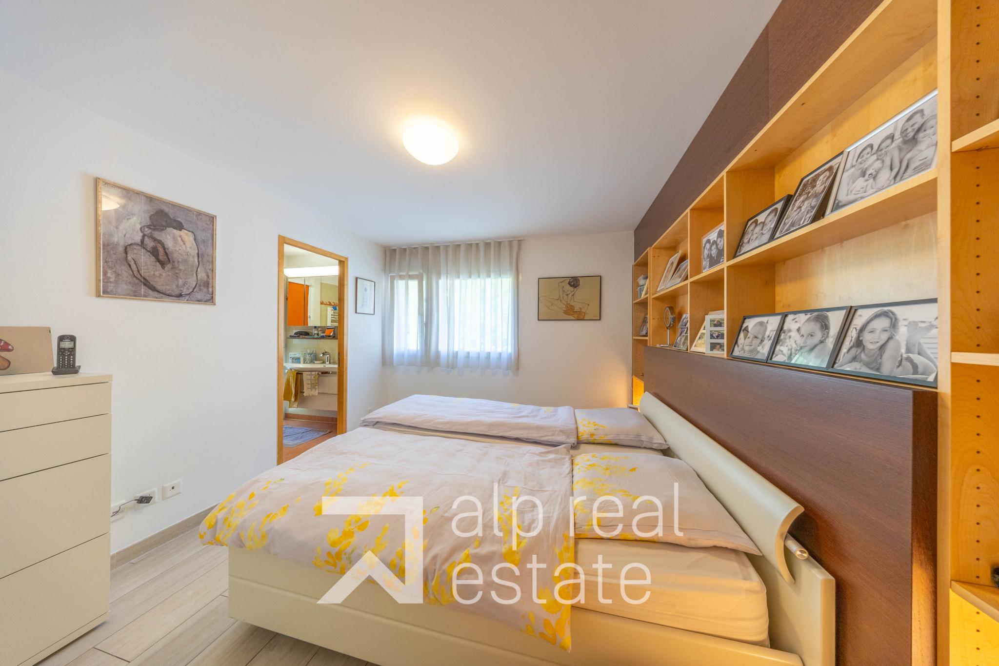 Helles Schlafzimmer mit Doppelbett und Einbauregal