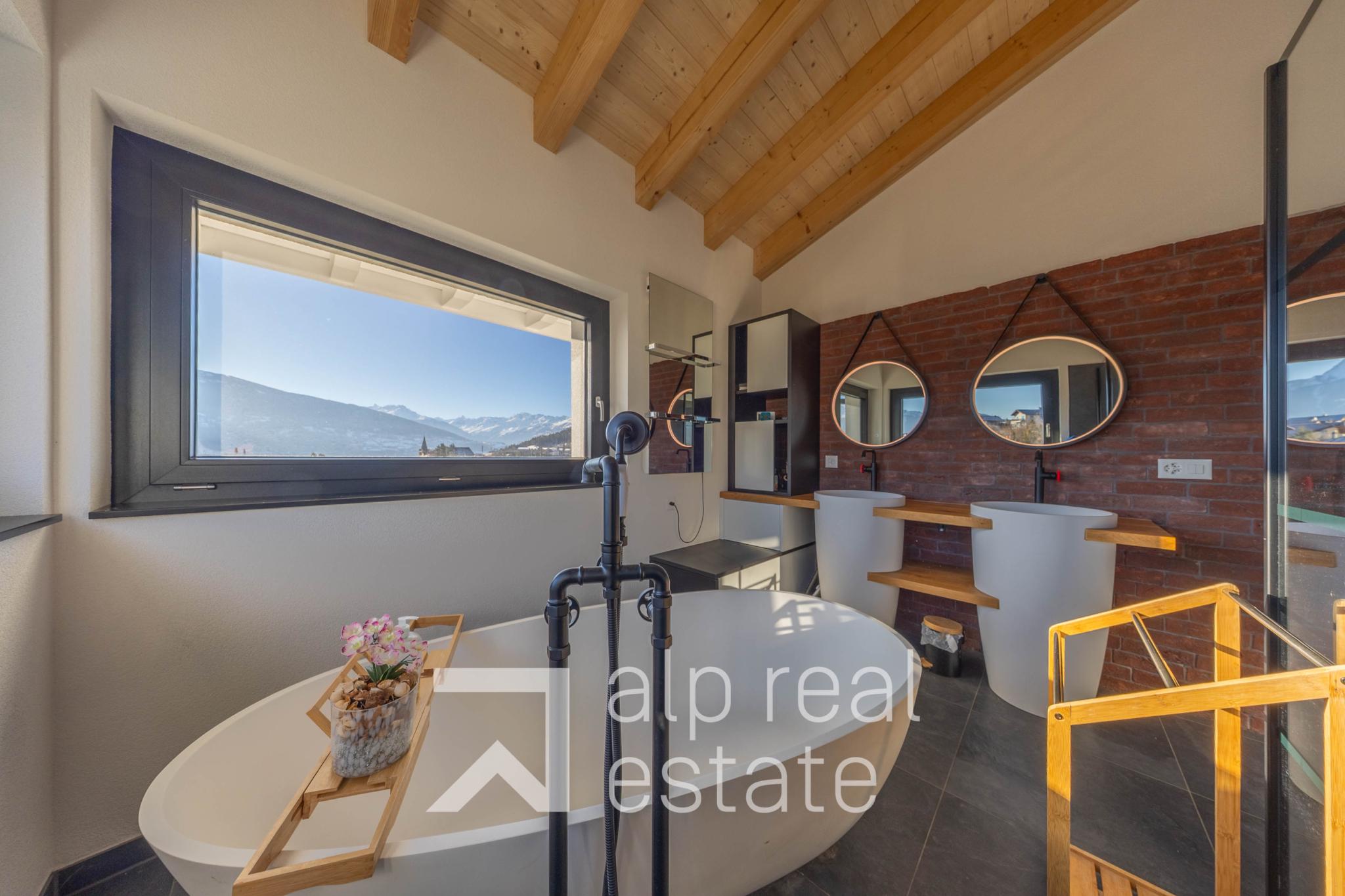 Modernes Badezimmer mit Dachschräge und Bergblick