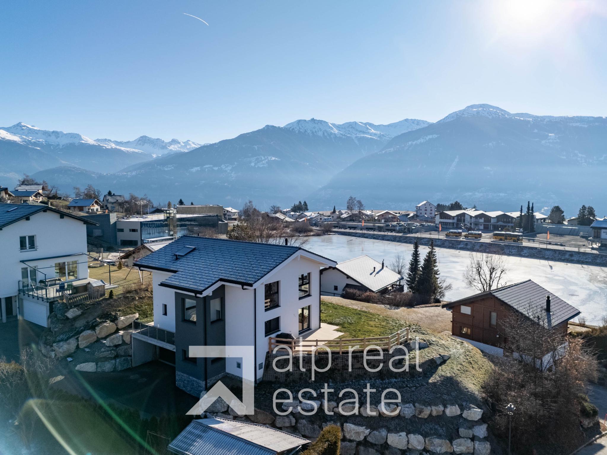 Alpenlandschaft mit Wohnhäusern und Seeblick