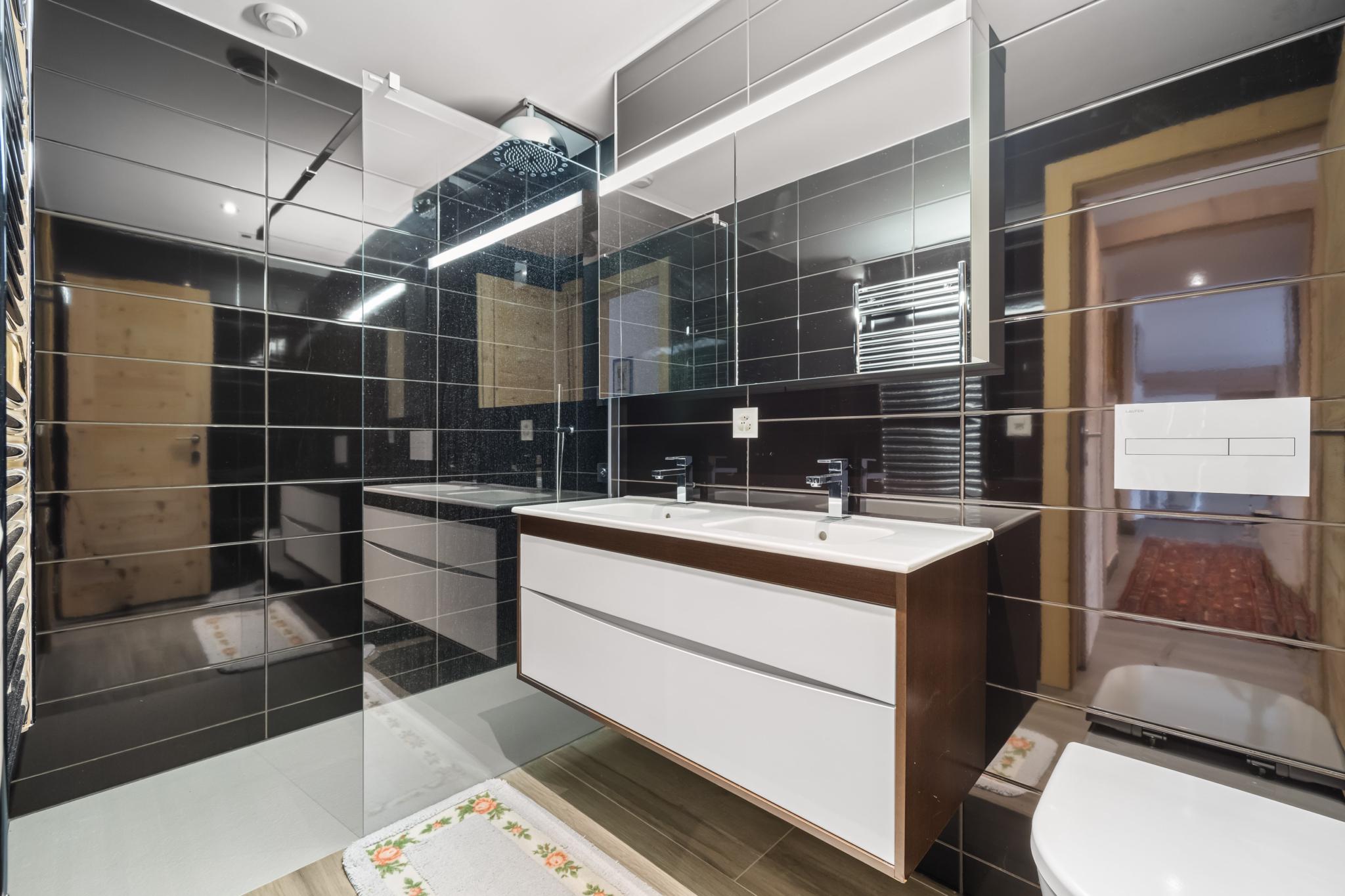 Modernes Badezimmer mit dunklen Wandfliesen