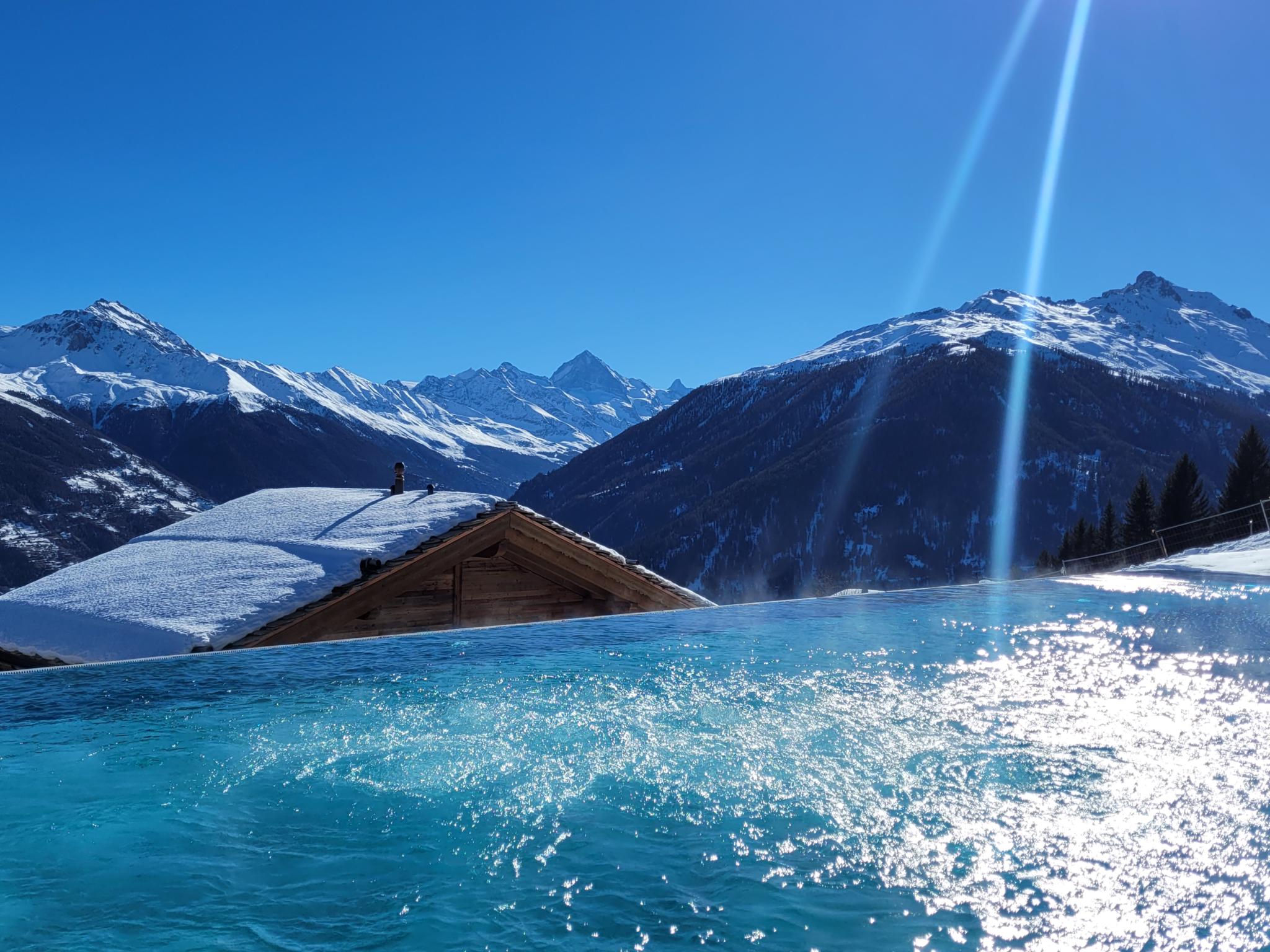 Schneebedeckter Infinity-Pool mit Alpenblick
