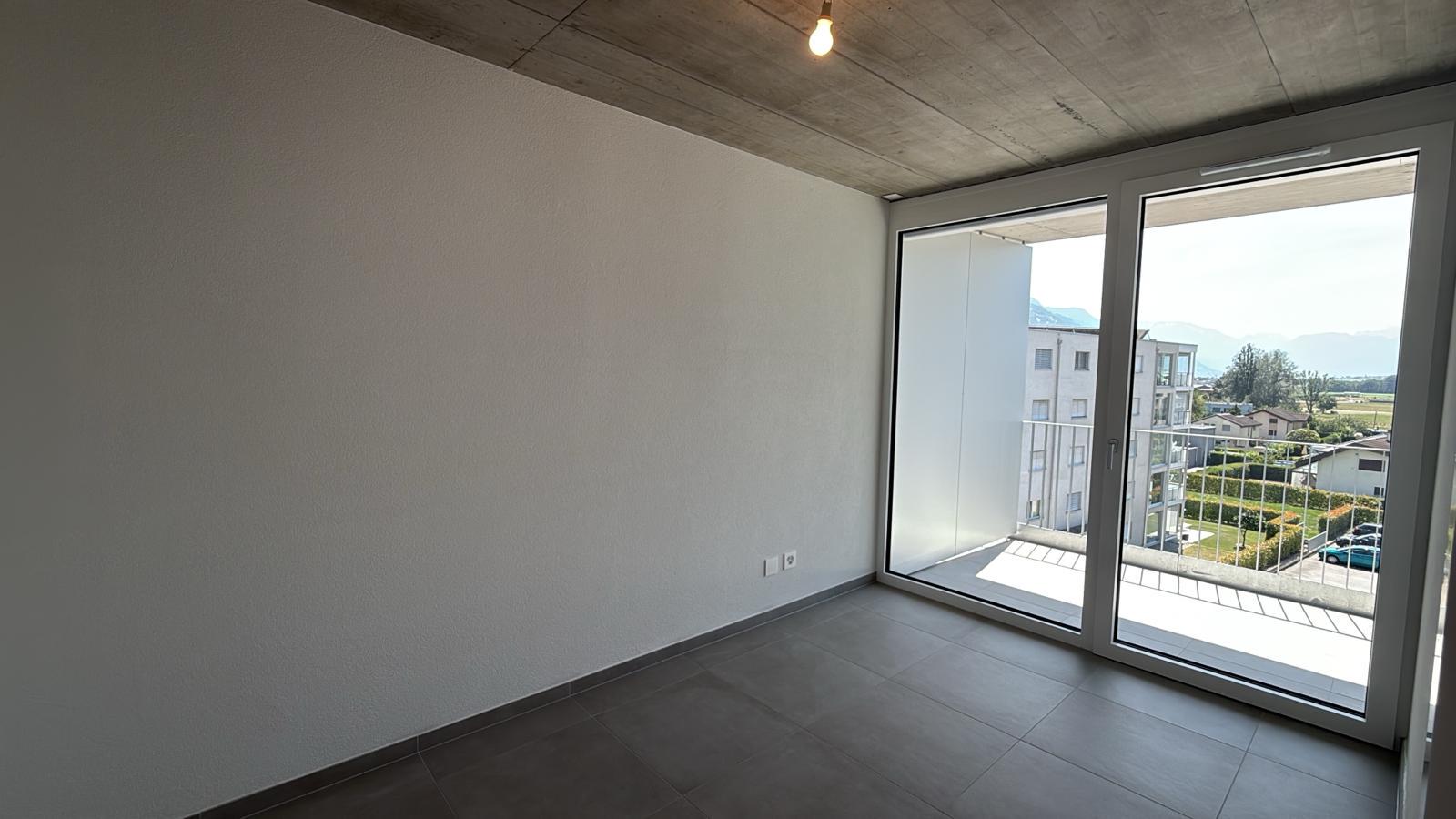 Helles, leeres Zimmer mit Balkon und Bergblick