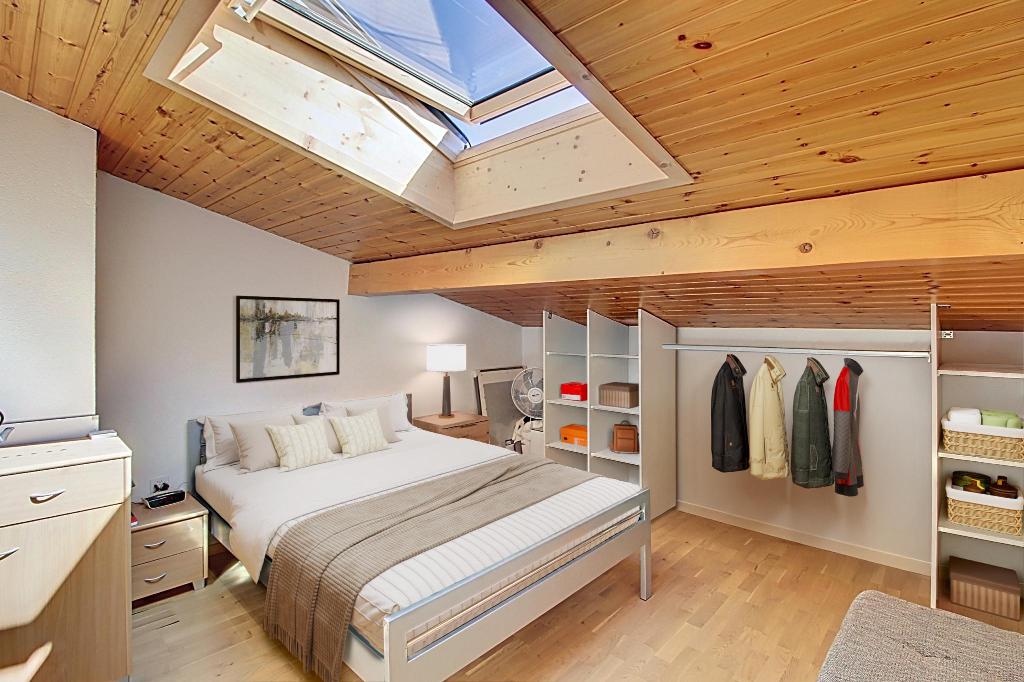 Dachgeschoss-Schlafzimmer mit Kleiderschrank und Dachfenster