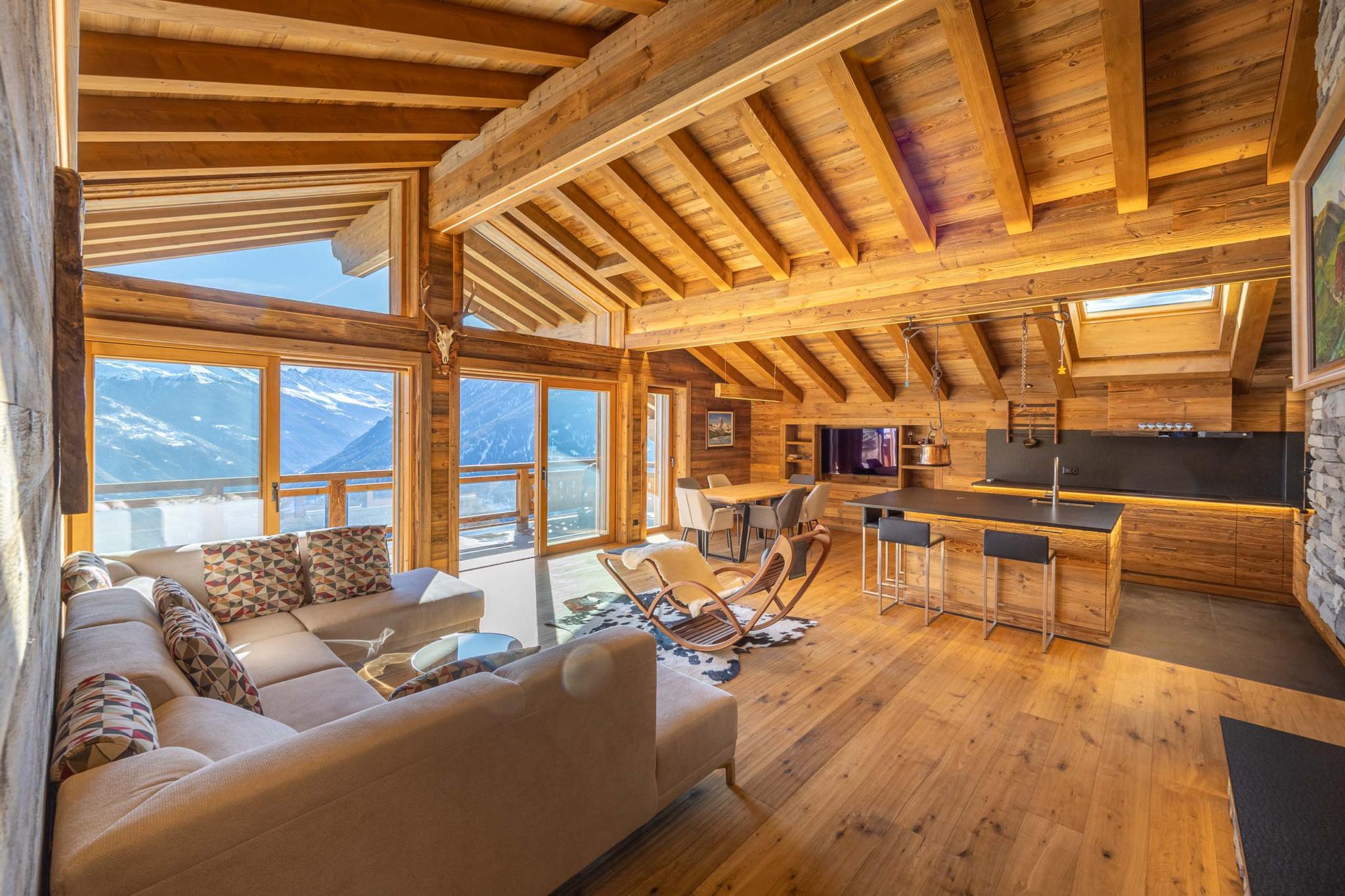 Gemütlicher alpiner Wohnbereich mit offener Küche und Bergblick