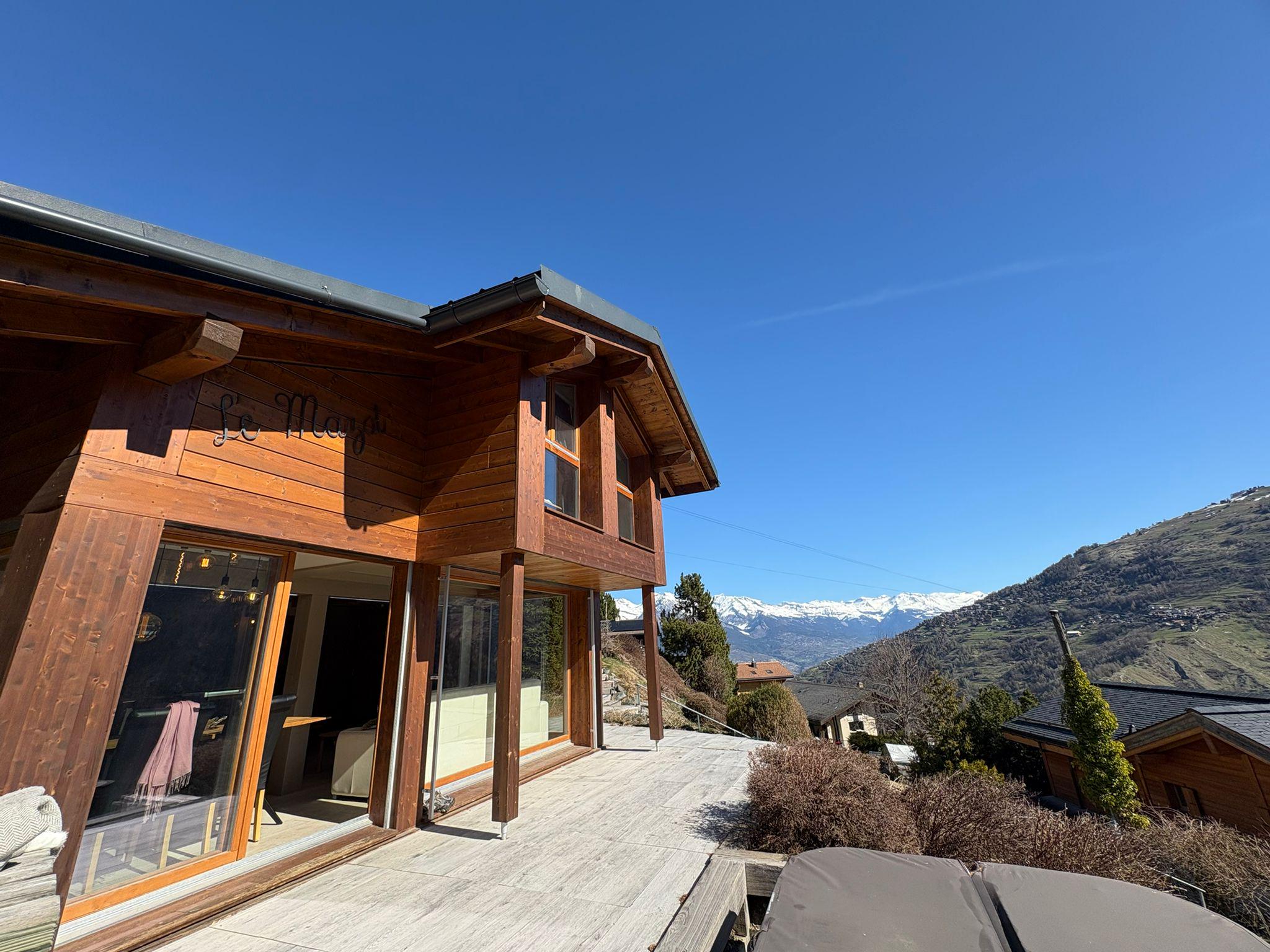 Alpines Holzhaus mit Bergpanorama