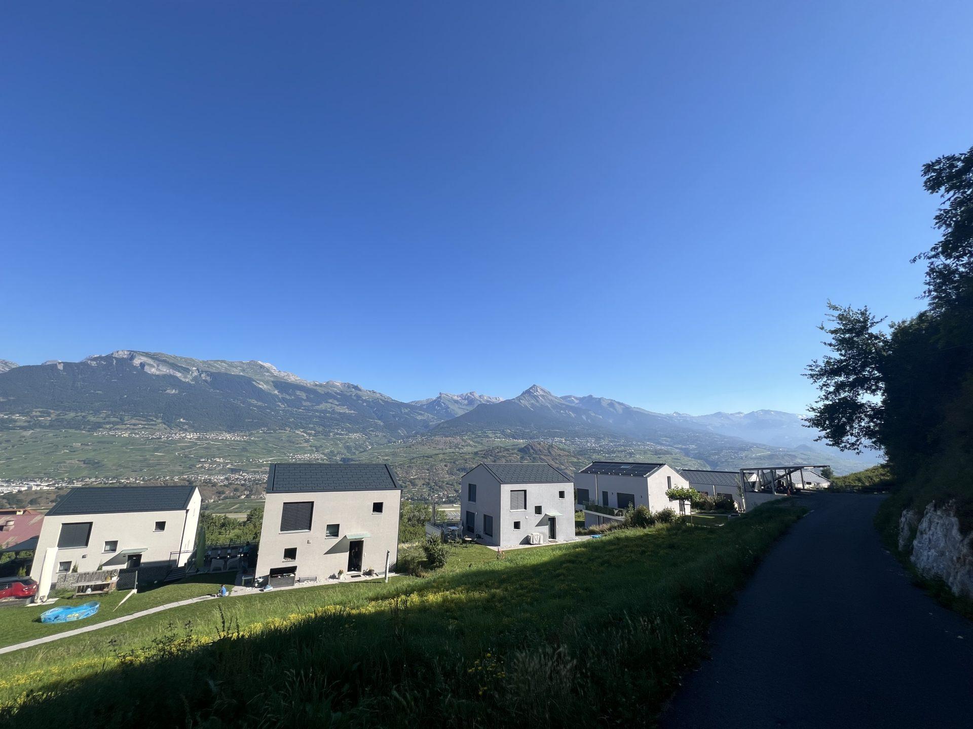 Alpiner Wohnhang mit moderner Neubausiedlung