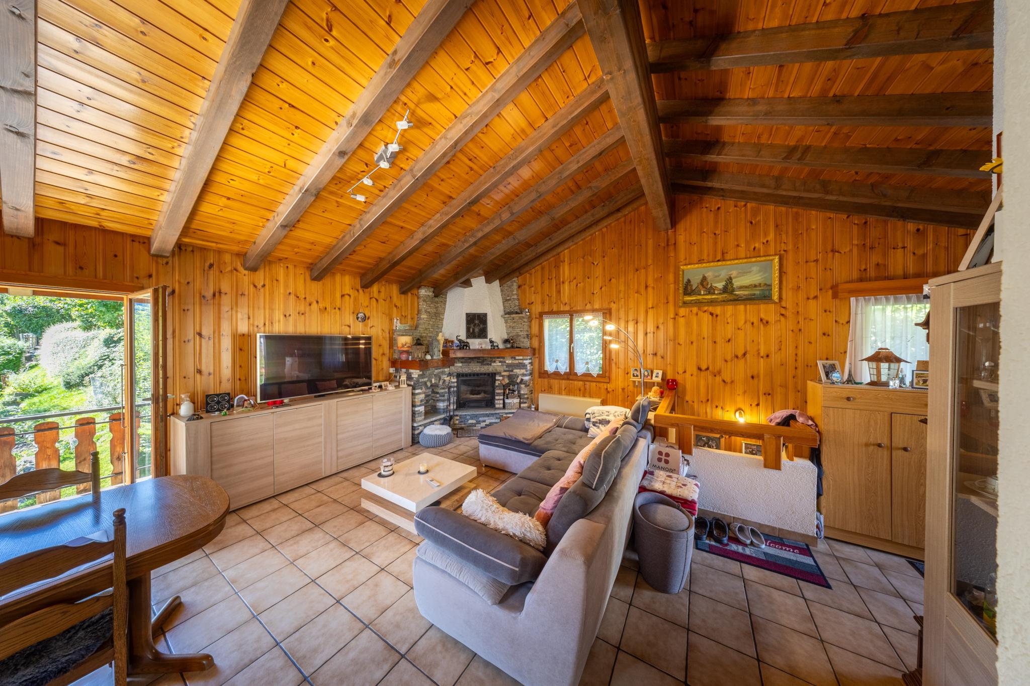Gemütliches Wohnzimmer mit Holzdecke und Kamin