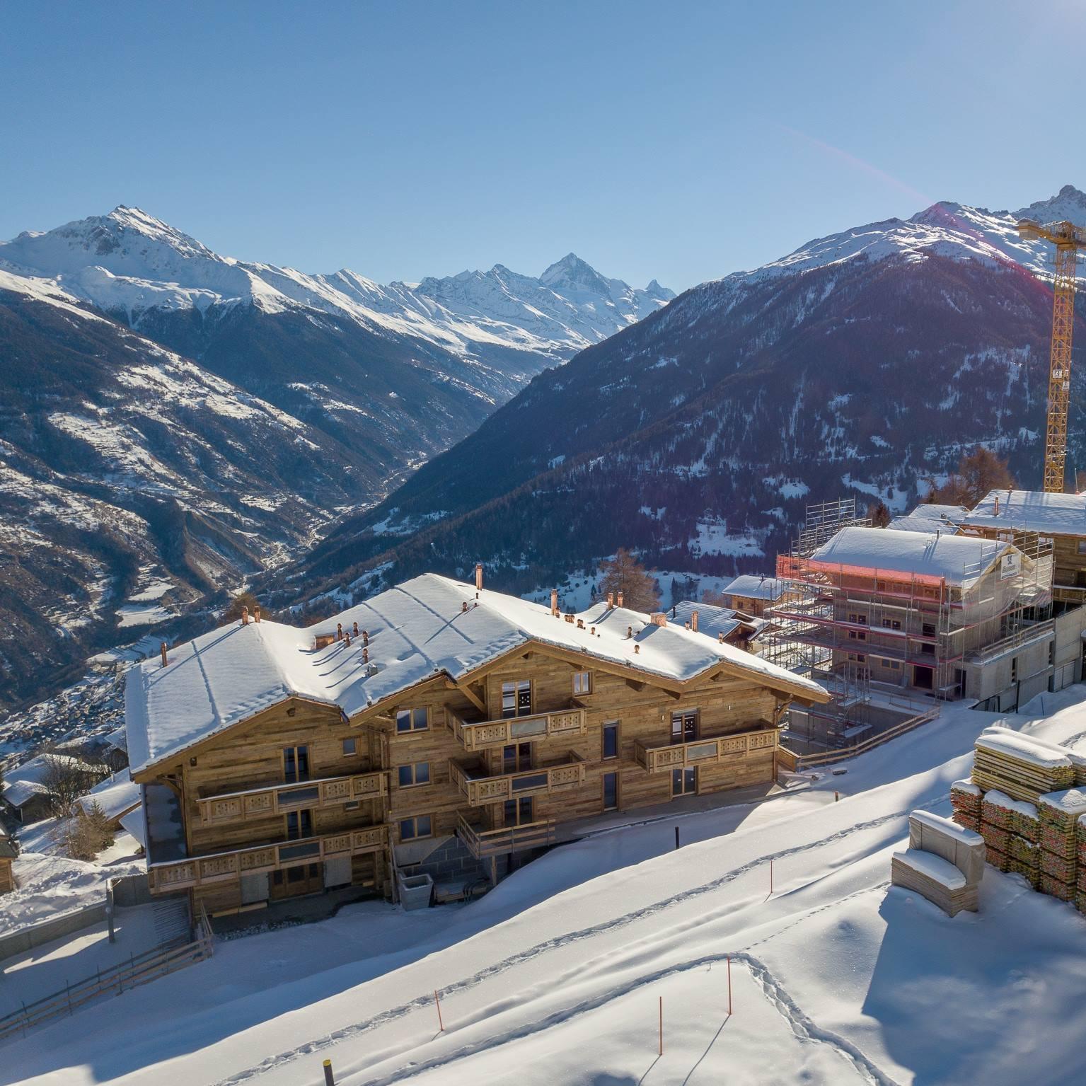 Alpine Baugrundstück mit Schnee und Bergpanorama
