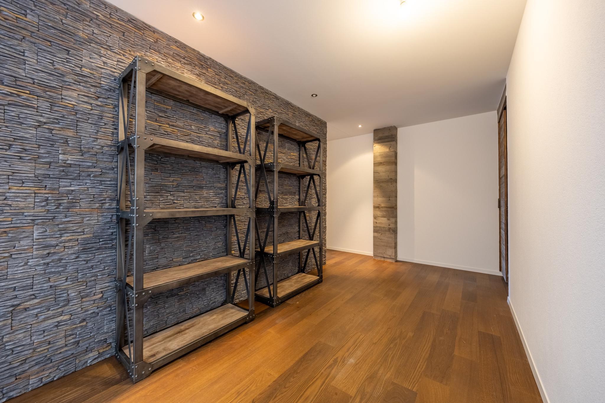 Moderner Flur mit Regalen und Steinwand