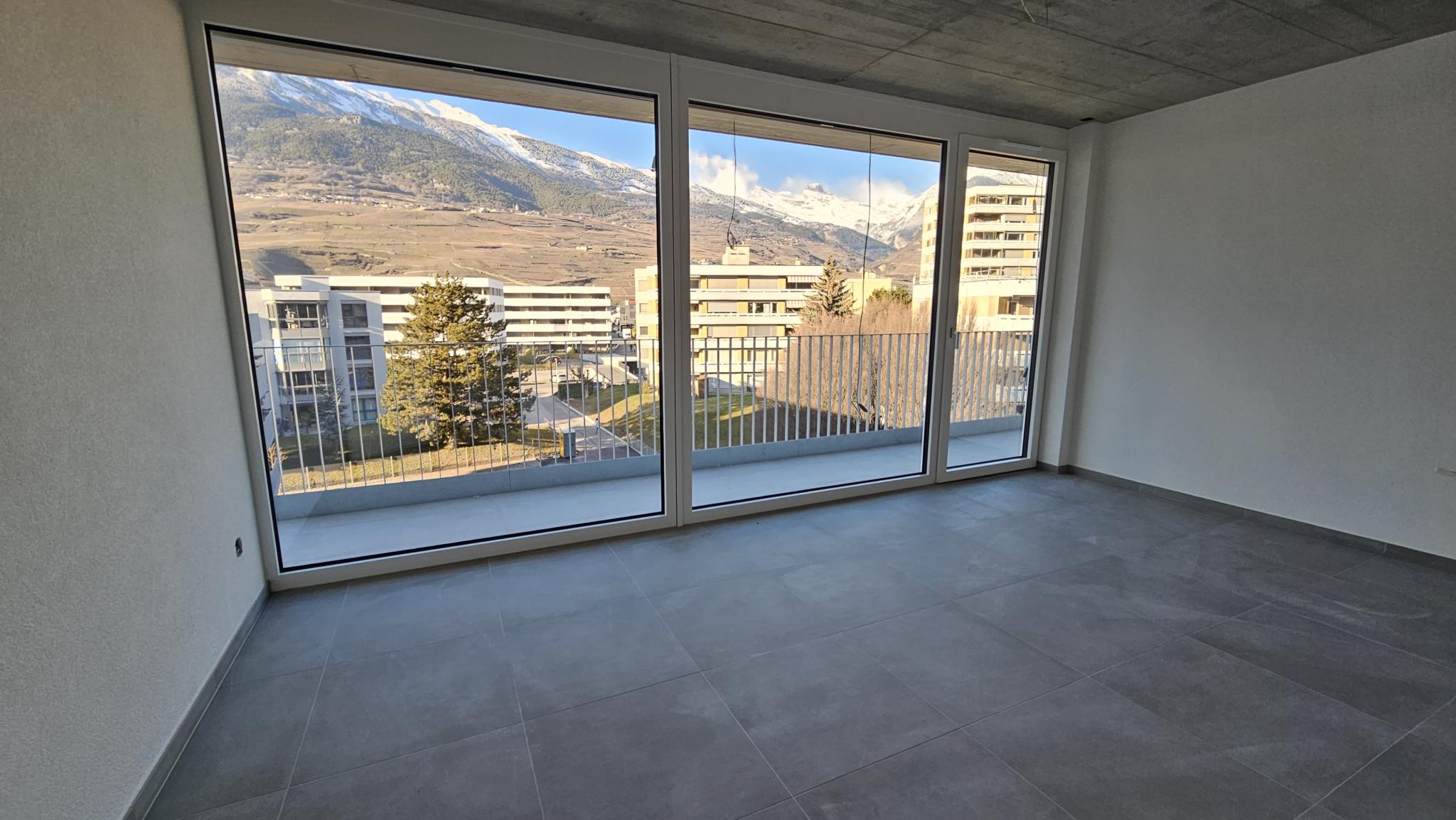 Leerer Wohnraum mit Panoramafenstern und Bergblick