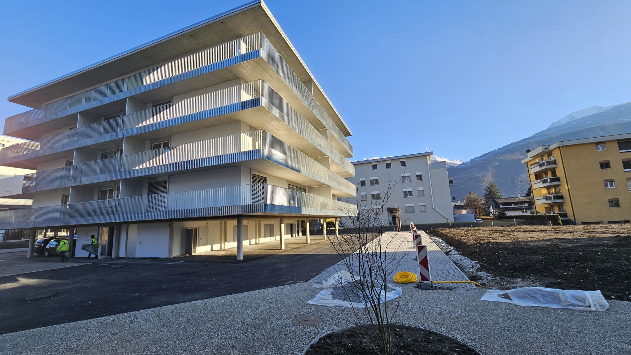Modernes Mehrfamilienhaus mit Terrassen und Bergblick