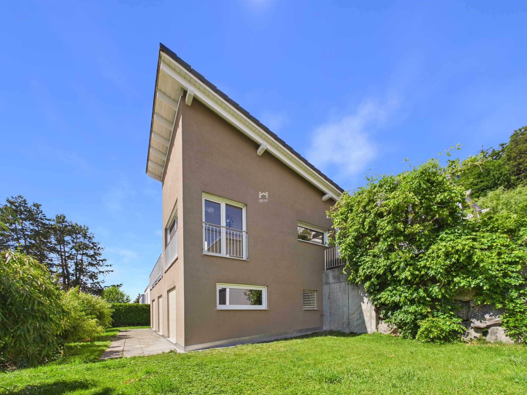 Modernes Einfamilienhaus mit geneigtem Dach und Garten