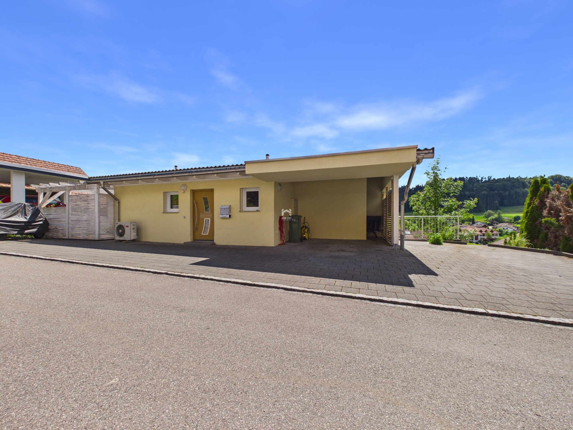 Außenansicht eines eingeschossigen Hauses mit Carport