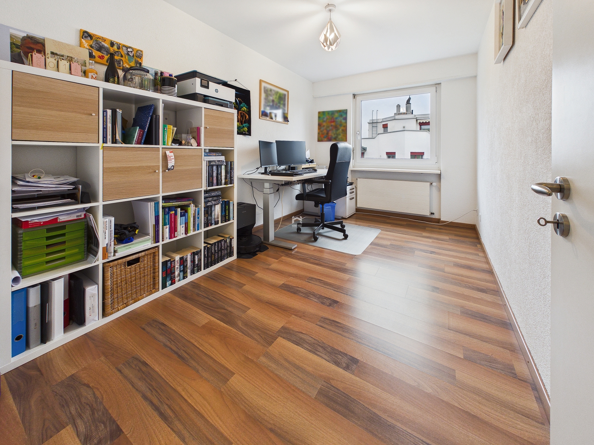 Arbeitszimmer mit Regalwand und Schreibtisch