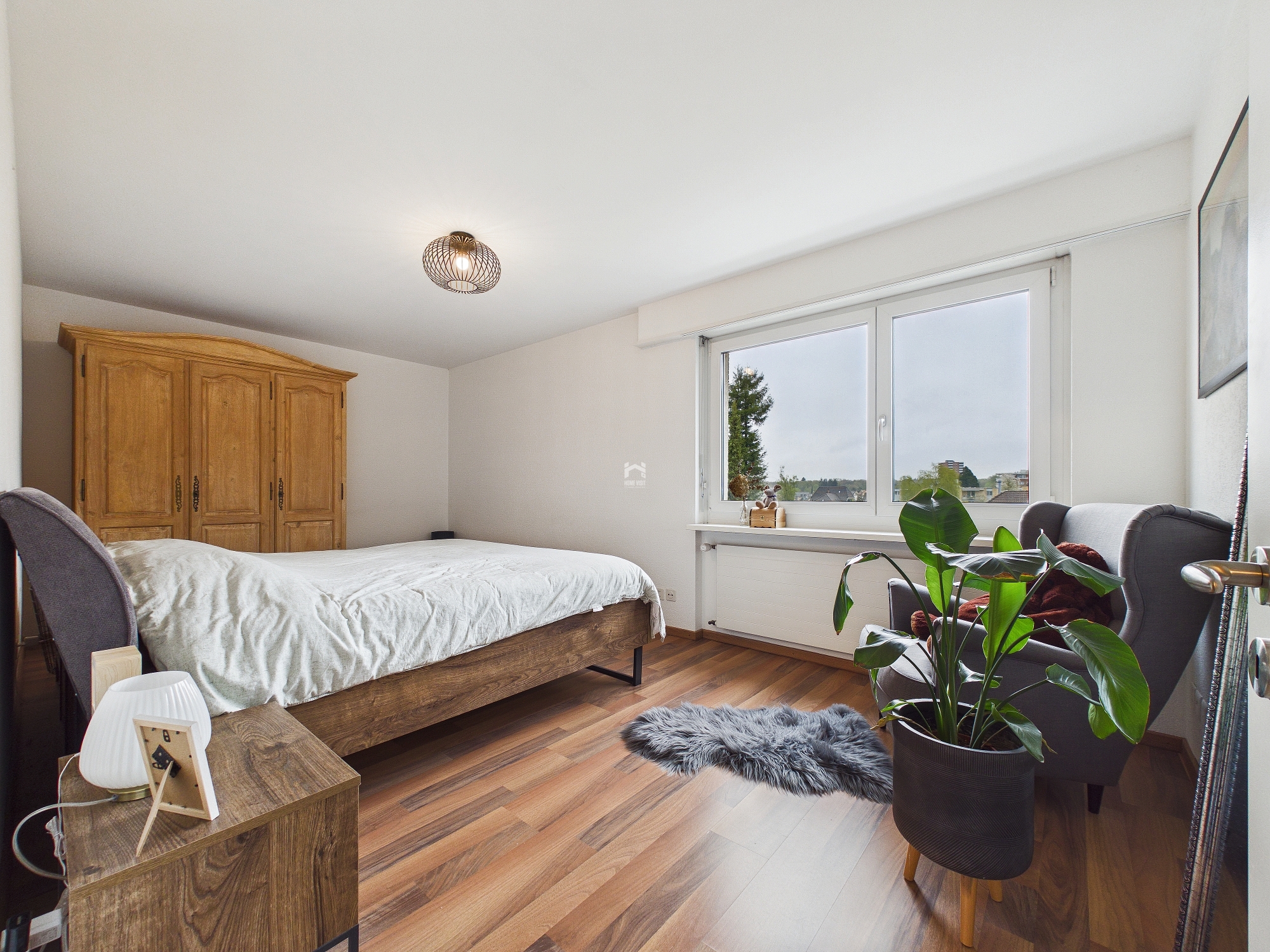Schlafzimmer mit Holzdetails und Blick ins Grüne