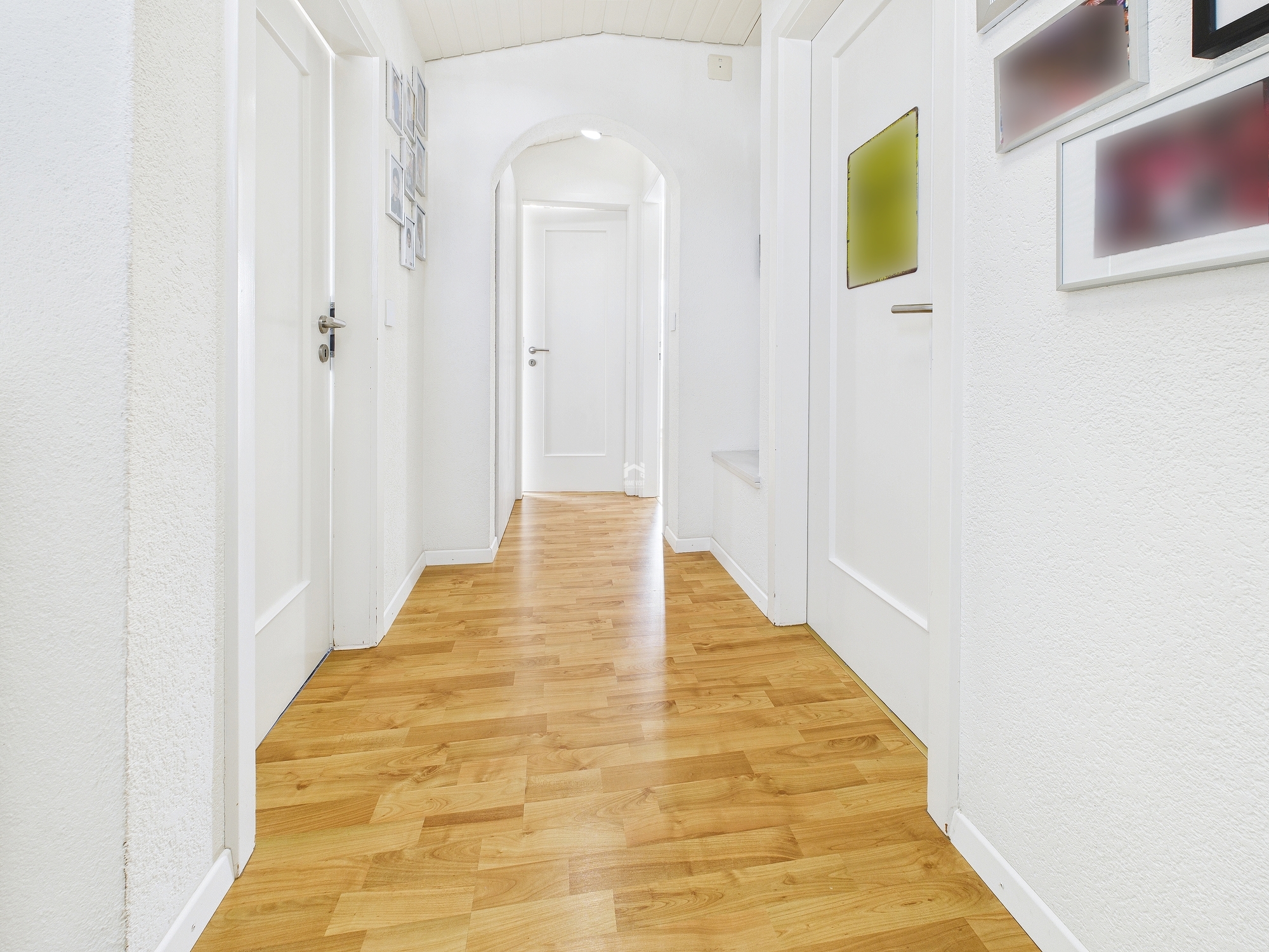 Heller Flur mit Holzboden und weißen Türen