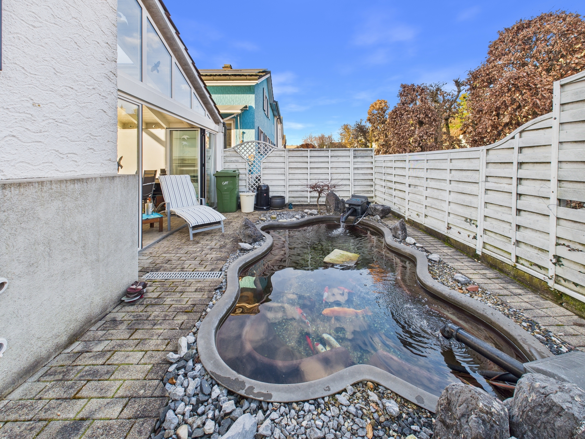 Terrasse mit Gartenteich und Hauszugang
