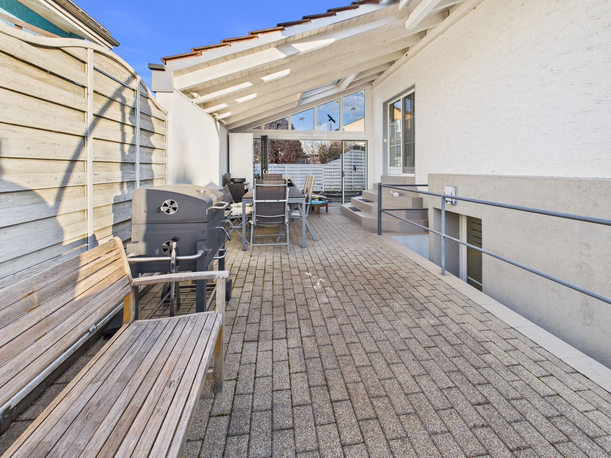Überdachte Dachterrasse mit Sitzbereich und Grill