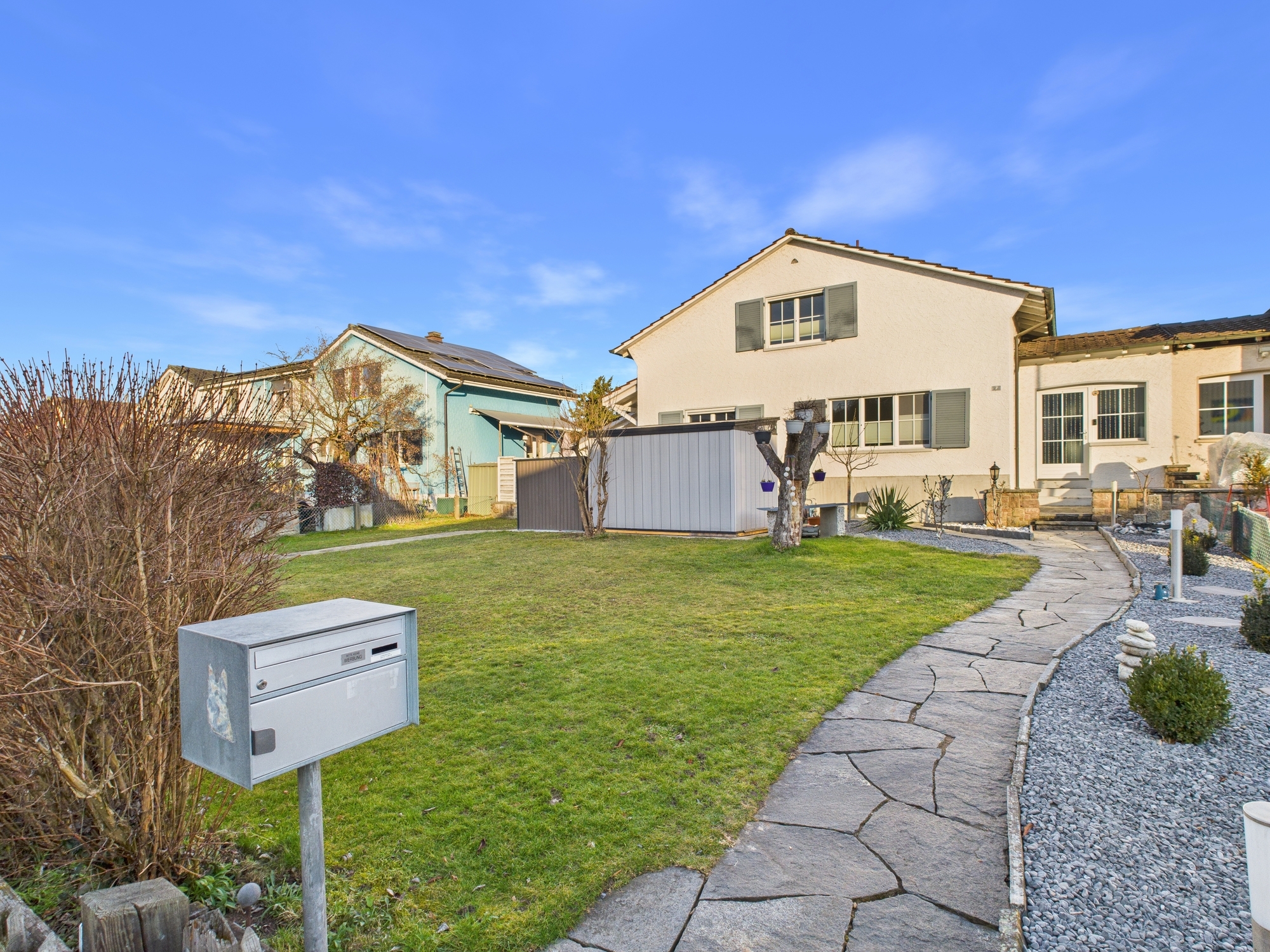 Einfamilienhaus mit Garten und gepflastertem Weg