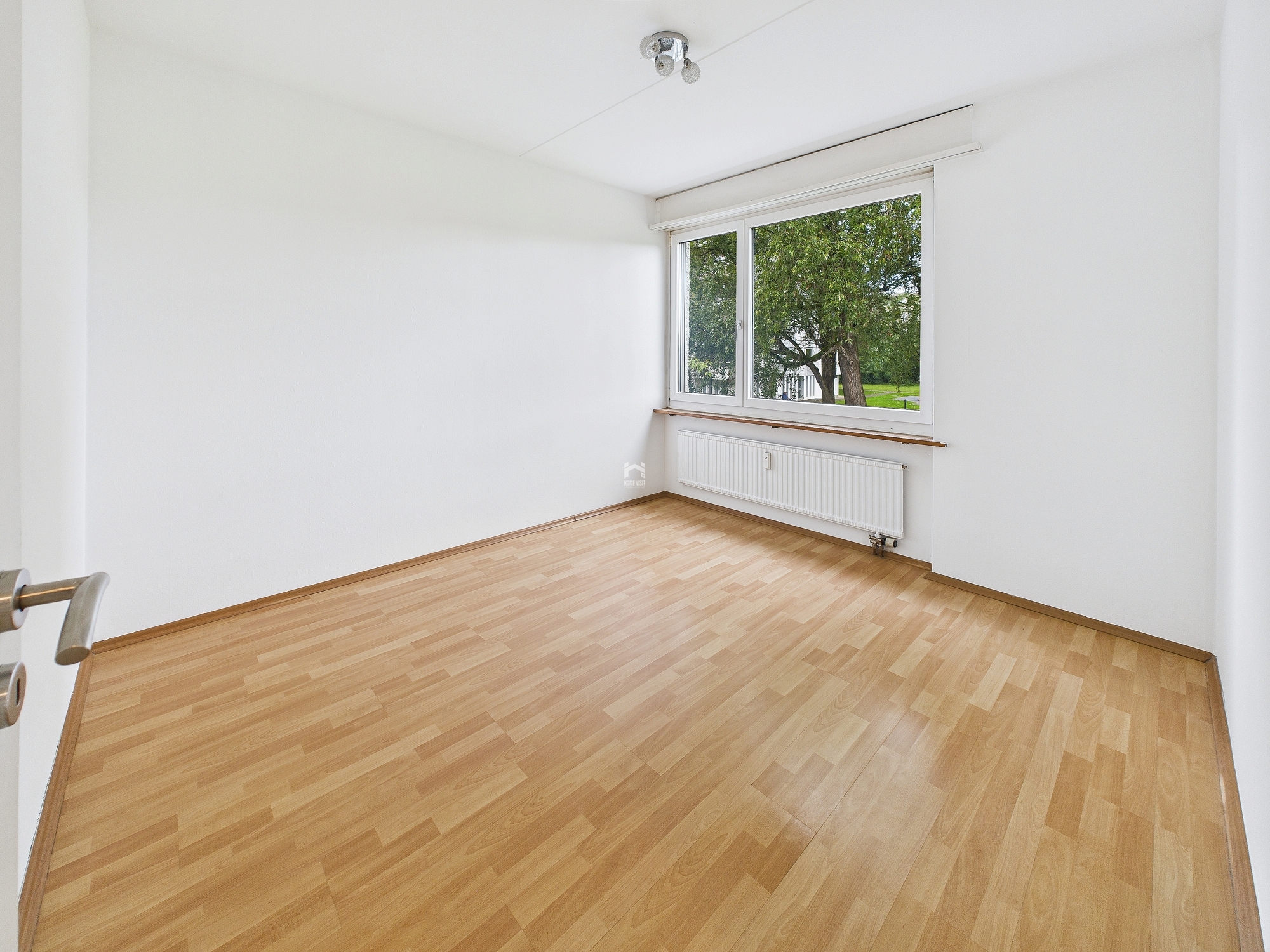Leerer heller Raum mit Fensterblick ins Grüne