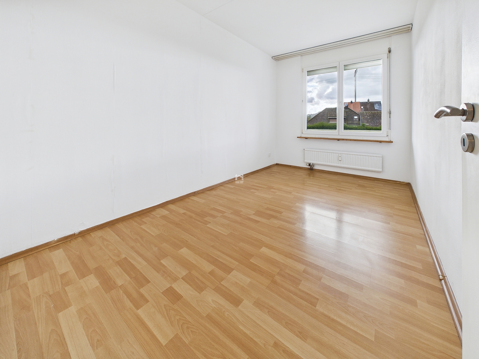 Heller leerer Raum mit Laminatboden und Fenster