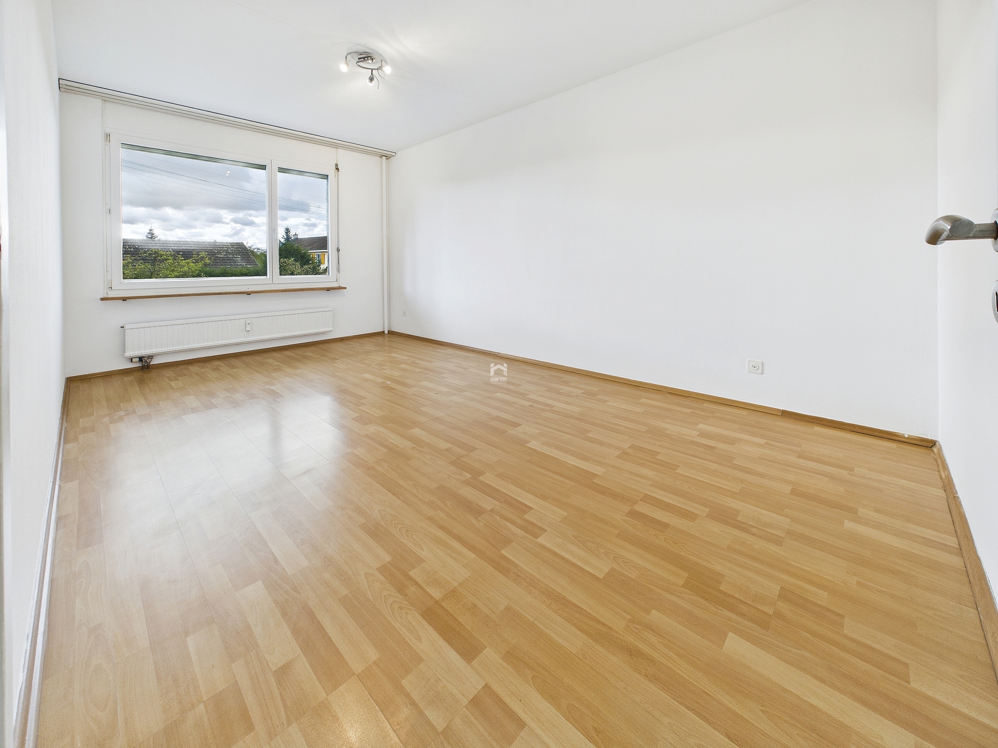 Leeres Zimmer mit Laminatboden und Fenster