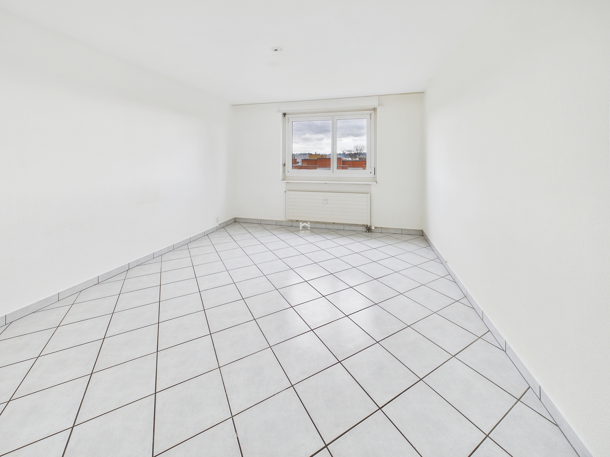 Leerer heller Raum mit Fliesenboden und Fenster