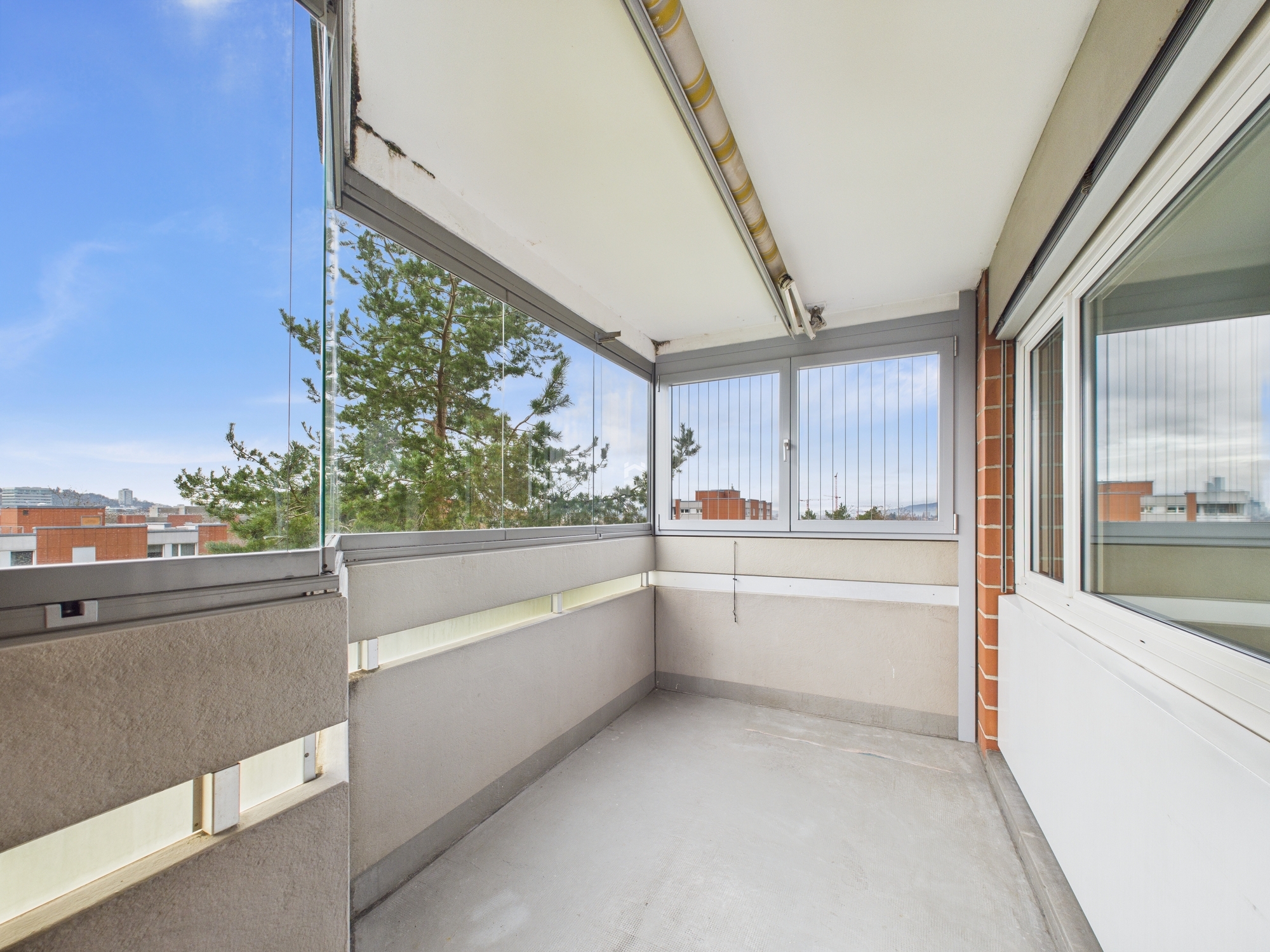 Verglaster Balkon mit Stadtblick
