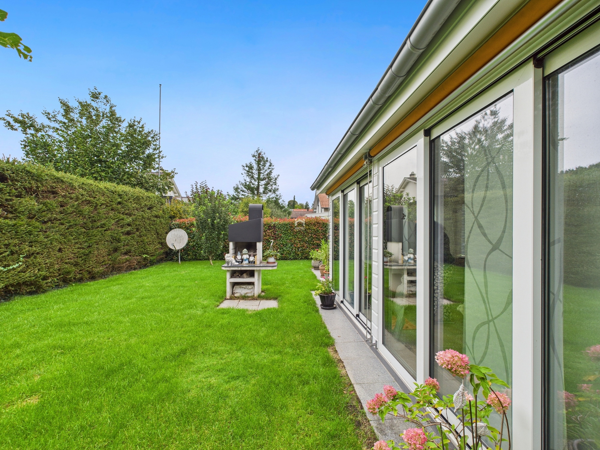 Gepflegter Garten mit moderner Glasfassade