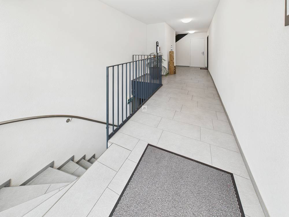 Heller Flur mit Treppe und Geländer