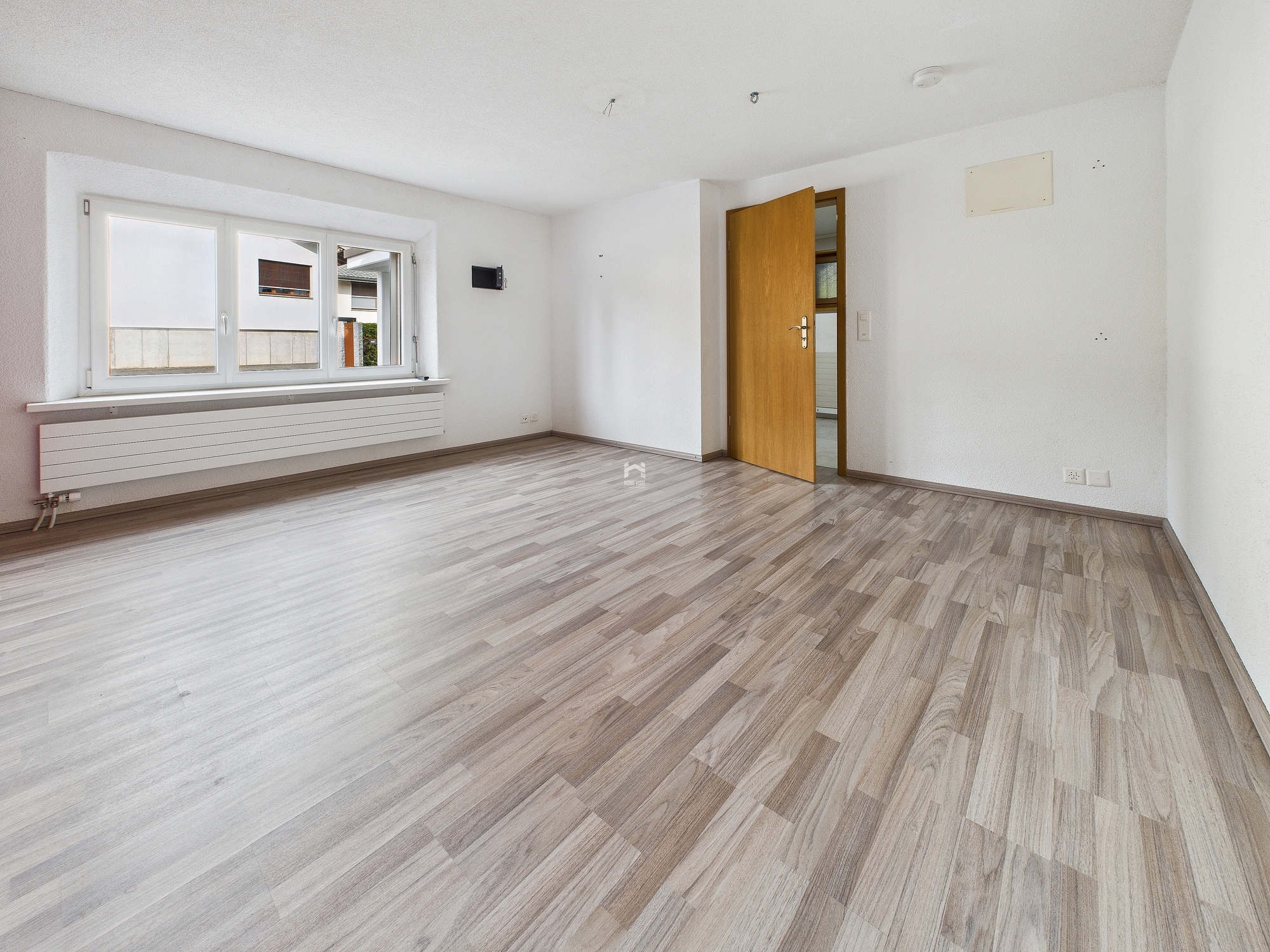 Leerer heller Wohnraum mit Holzlaminatboden