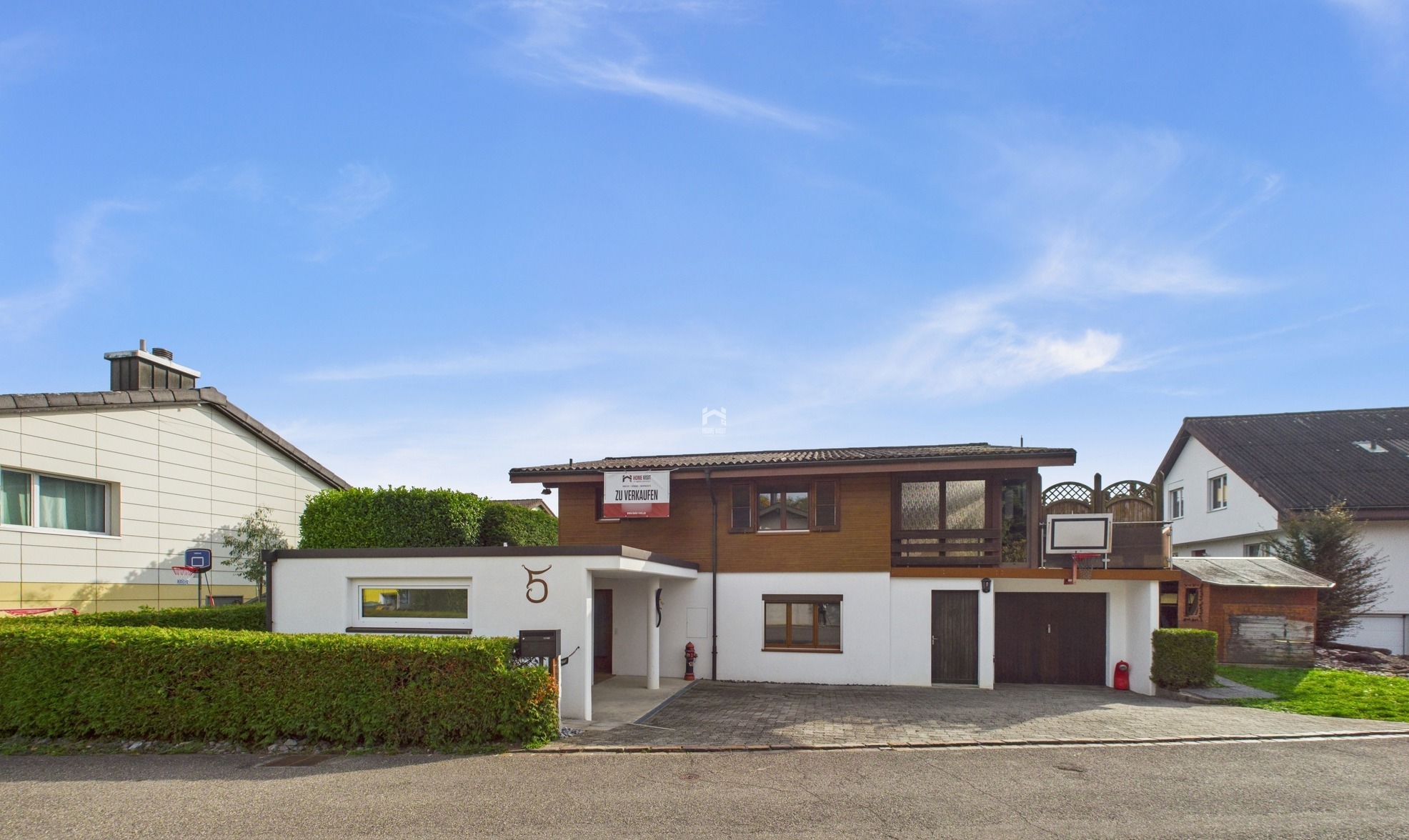 Wohnhaus mit Verkäuferschild und Garage