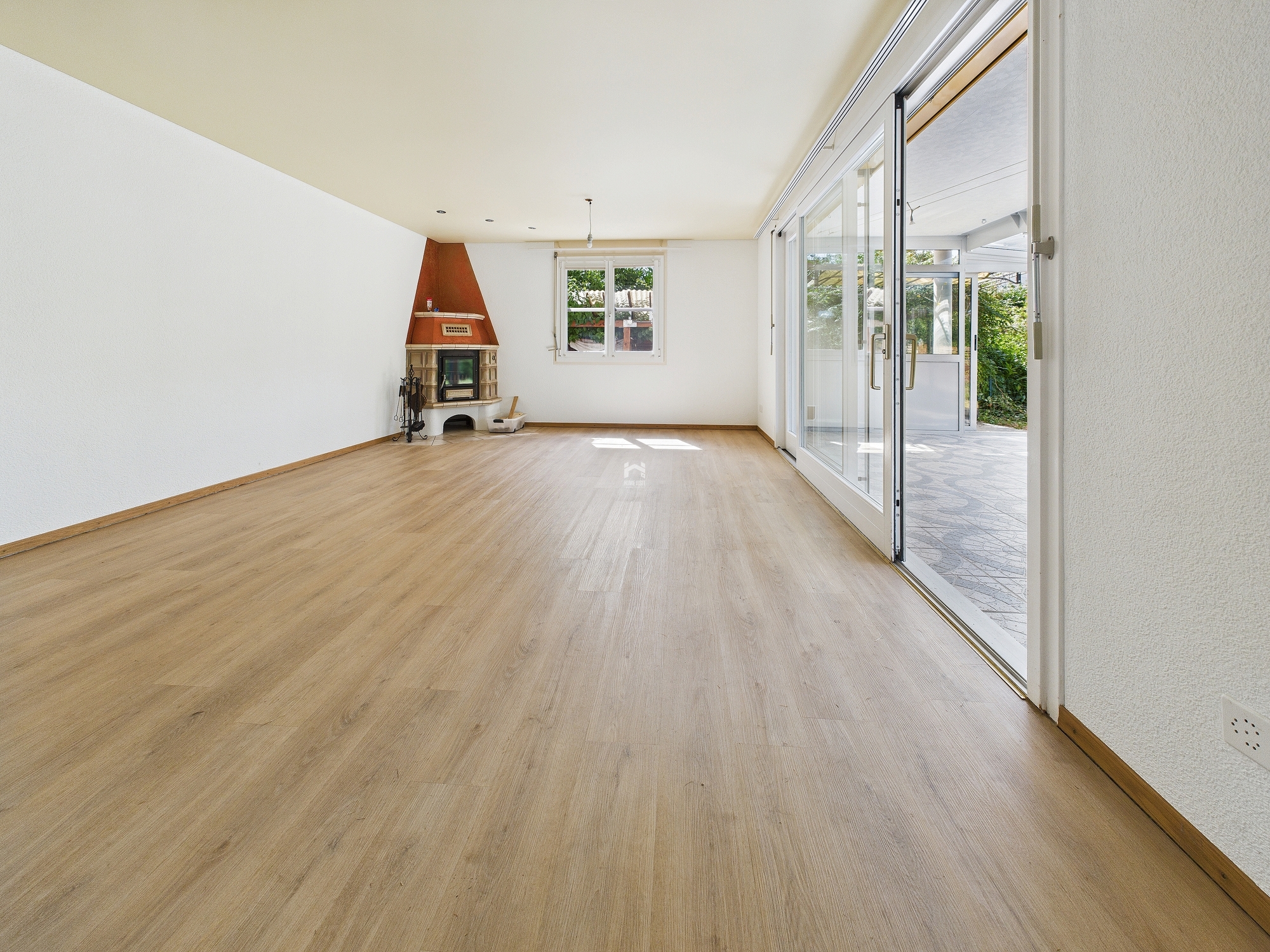 Heller Wohnraum mit Kamin und Terrassenzugang