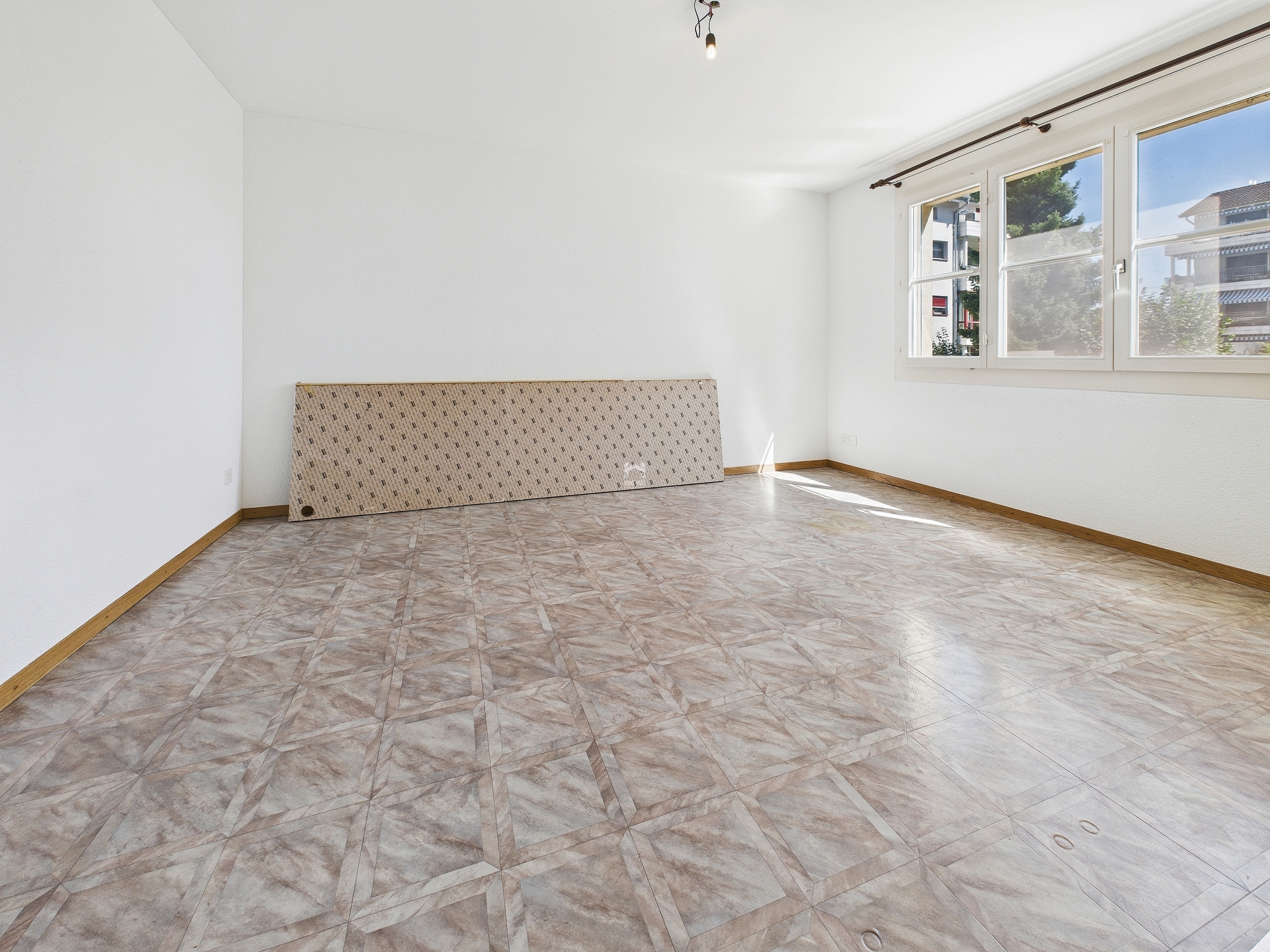 Leerer Wohnraum mit großen Fenstern