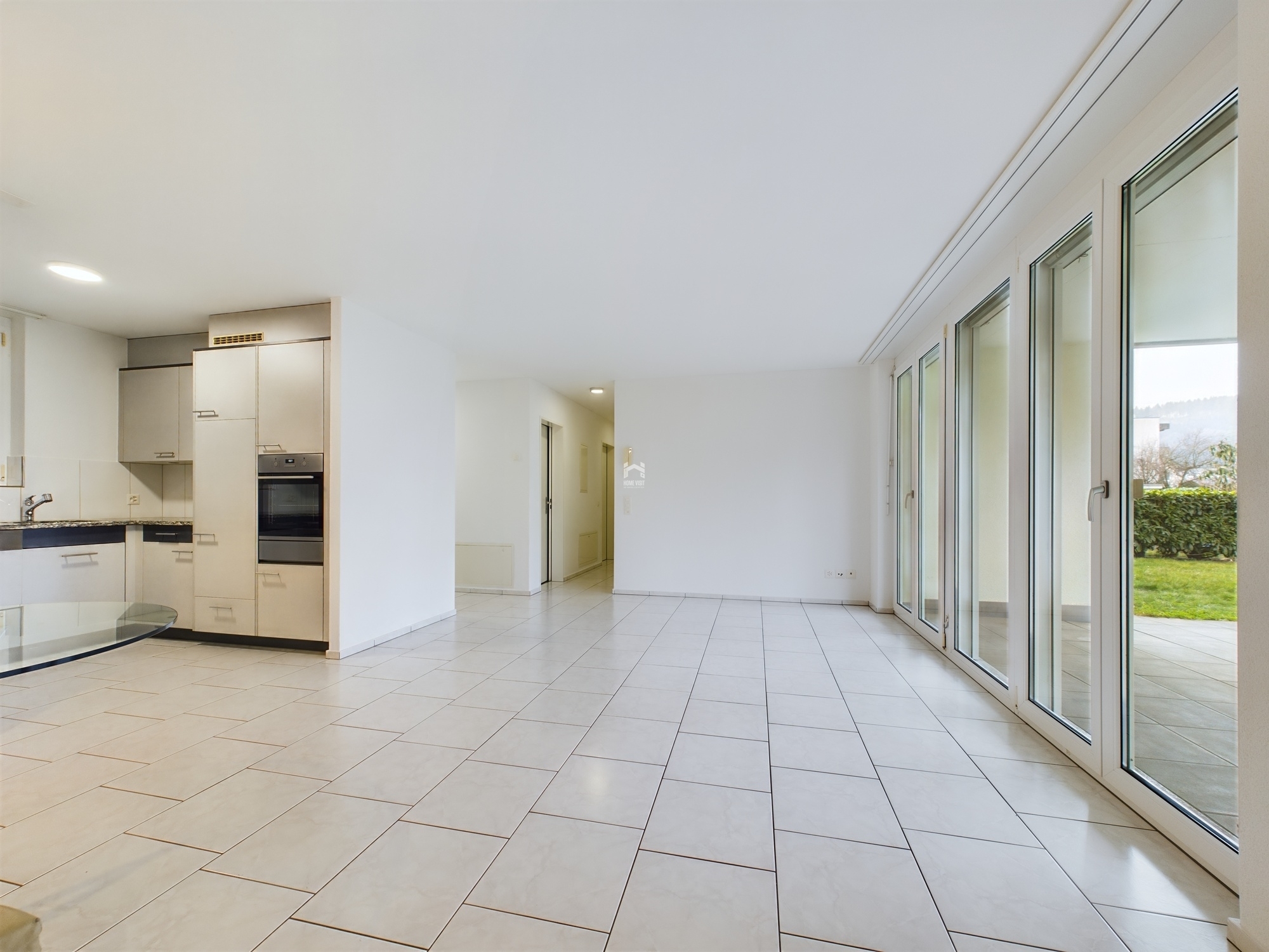 Offener Wohnbereich mit Küche und großen Fenstertüren