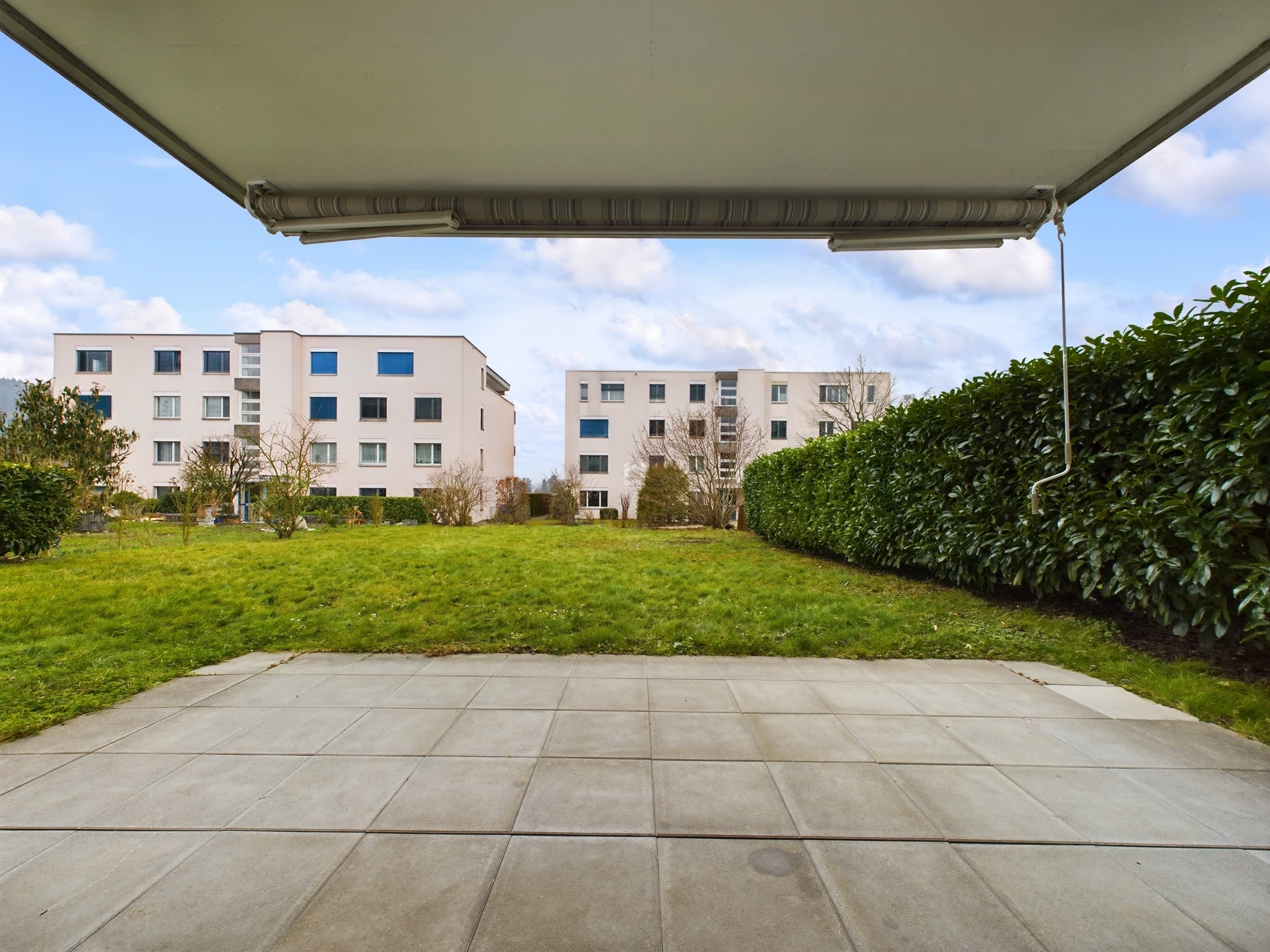Terrasse mit Blick ins Grün und auf Wohnblöcke