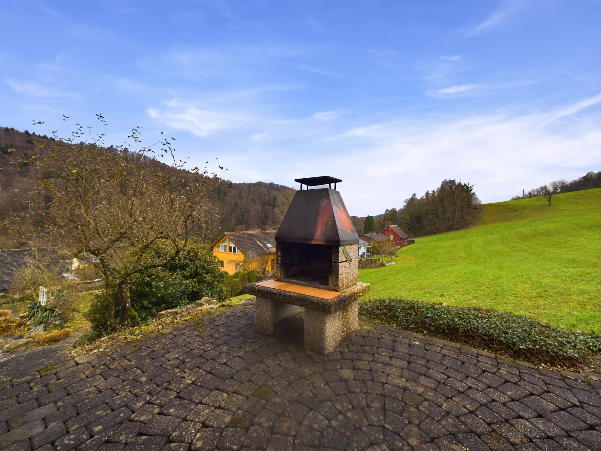 Außenbereich mit gemauertem Grill und Landschaft