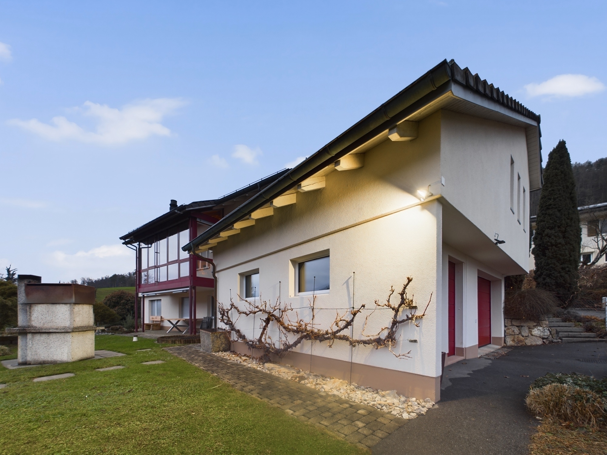 Modernes Einfamilienhaus mit geneigtem Dach und Garten